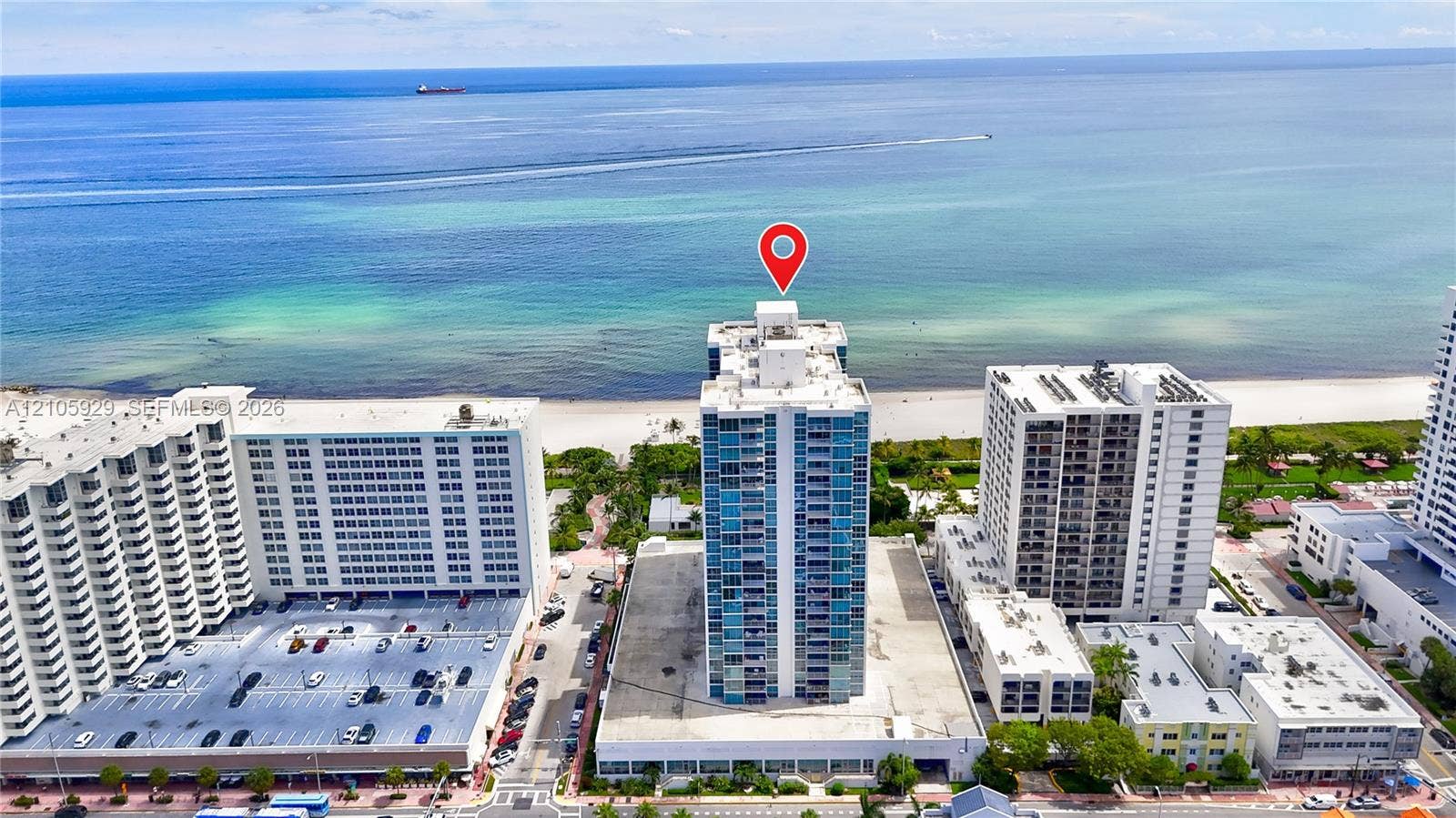 2655 Collins Avenue, #2301, Miami Beach, FL 33140 High-rise building featuring a glass facade, private balconies, and direct proximity to the oceanfront