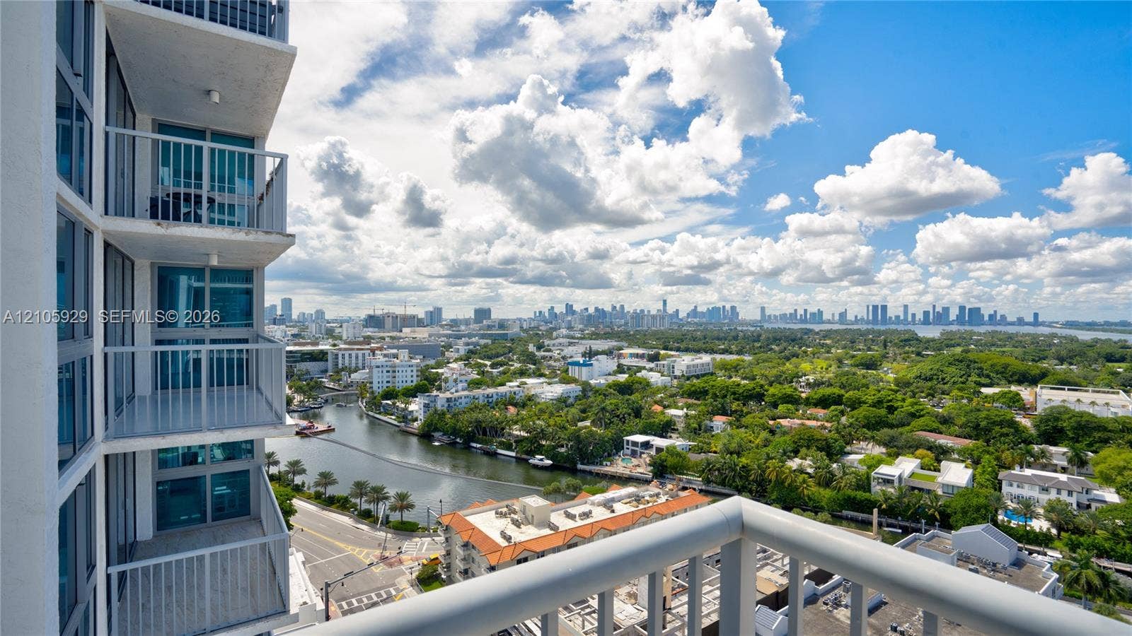 2655 Collins Avenue, #2301, Miami Beach, FL 33140 High-rise balcony featuring metal railings and floor-to-ceiling glass paneling, overlooking the surrounding cityscape and waterway
