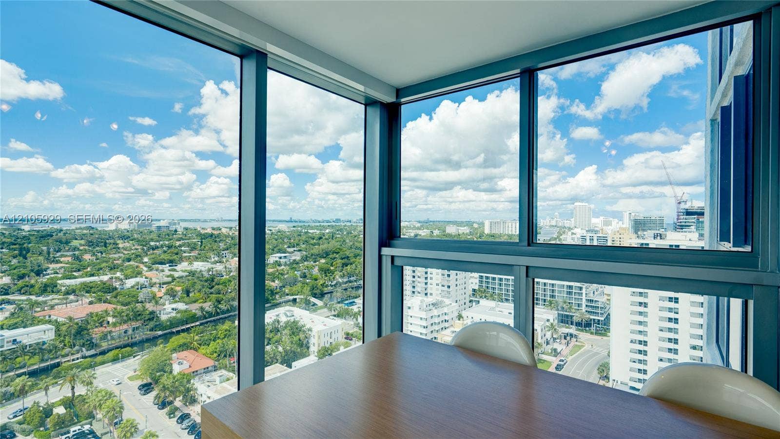 2655 Collins Avenue, #2301, Miami Beach, FL 33140 Floor-to-ceiling wrap-around windows featuring dark metal framing and panoramic urban and water scenery