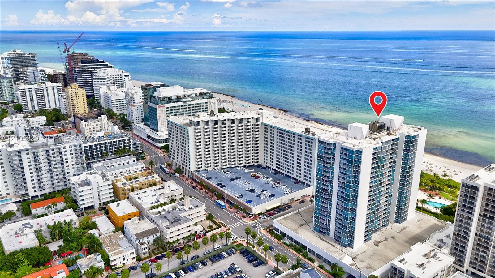 2655 Collins Avenue, #2301, Miami Beach, FL 33140 Aerial perspective of a high-rise residential building featuring expansive glass facade elements and proximity to the coastline