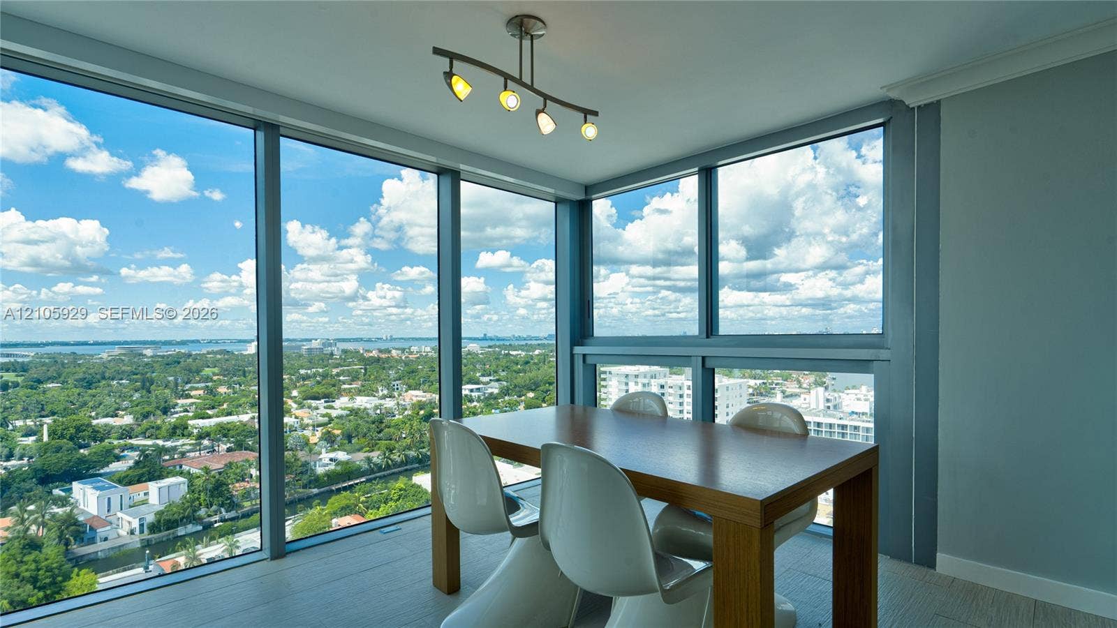 2655 Collins Avenue, #2301, Miami Beach, FL 33140 Floor-to-ceiling windows, panoramic exterior scenery, modern four-light ceiling fixture, and wood-finish flooring