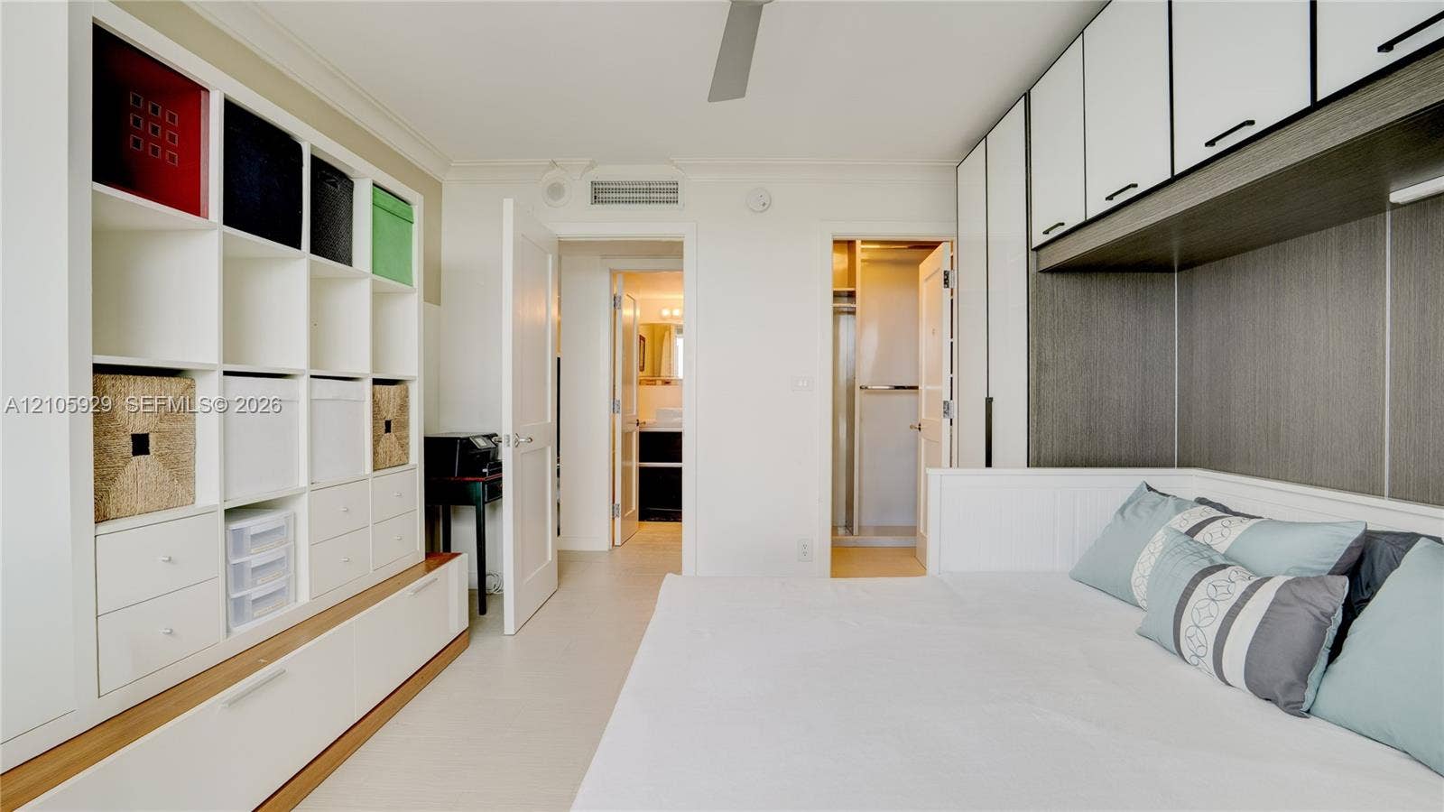 2655 Collins Avenue, #2301, Miami Beach, FL 33140 Room featuring extensive built-in white shelving, custom cabinetry with integrated overhead storage, ceiling-mounted fan, and tile flooring