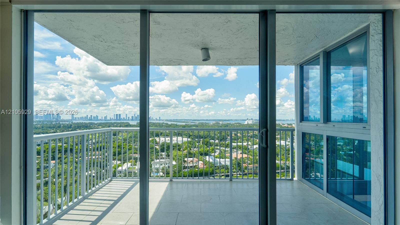 2655 Collins Avenue, #2301, Miami Beach, FL 33140 Covered balcony featuring metal railings, tile flooring, built-in ceiling lighting, and floor-to-ceiling glass sliding doors