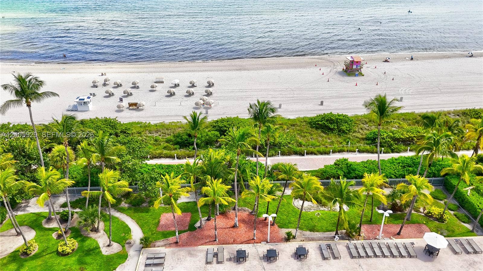2655 Collins Avenue, #2301, Miami Beach, FL 33140 Direct beachfront access featuring landscaped grounds with mature palm trees, paved pedestrian paths, and a stone-surfaced terrace