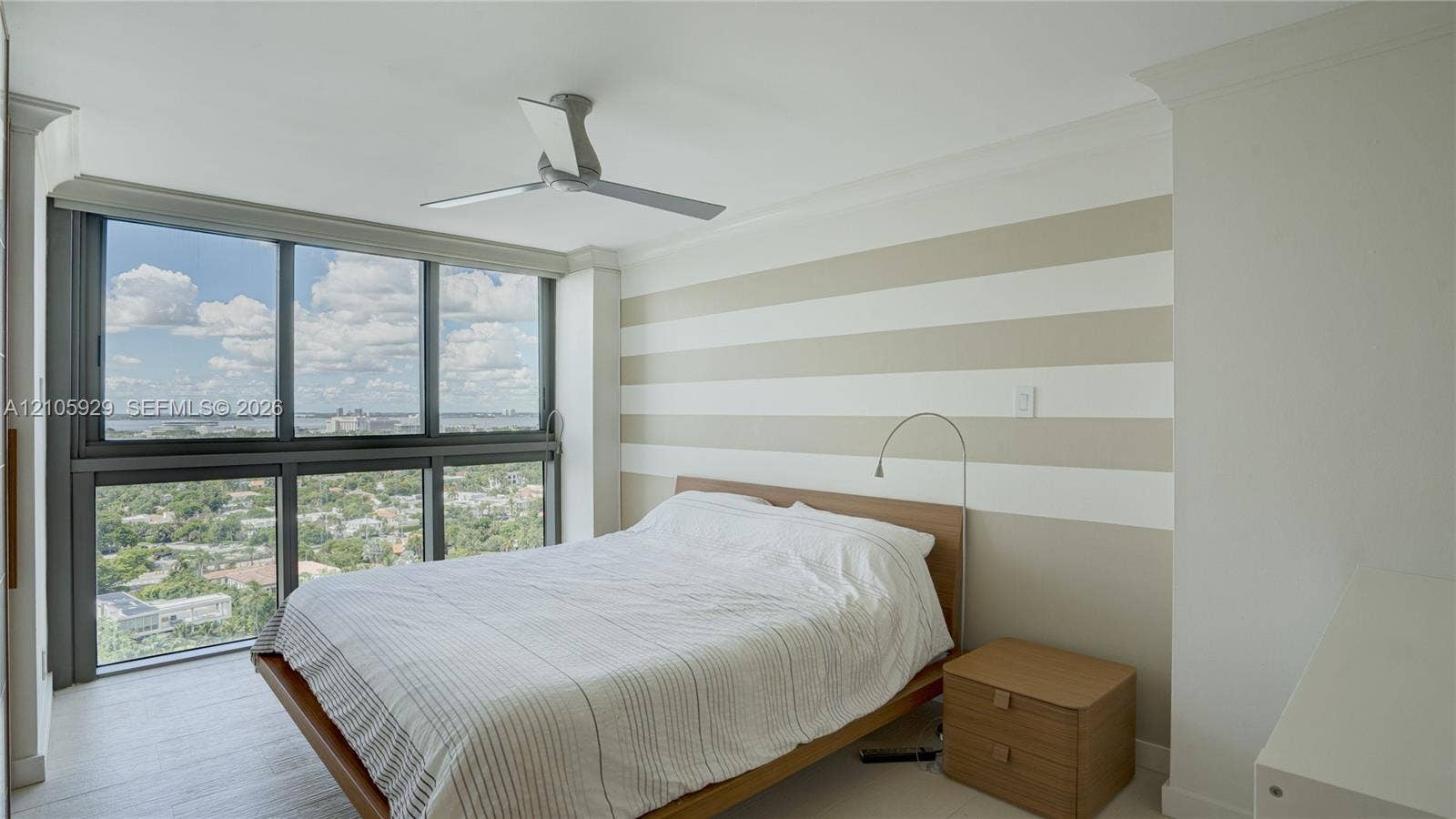2655 Collins Avenue, #2301, Miami Beach, FL 33140 Floor-to-ceiling windows, wood-finish flooring, ceiling fan, and crown molding