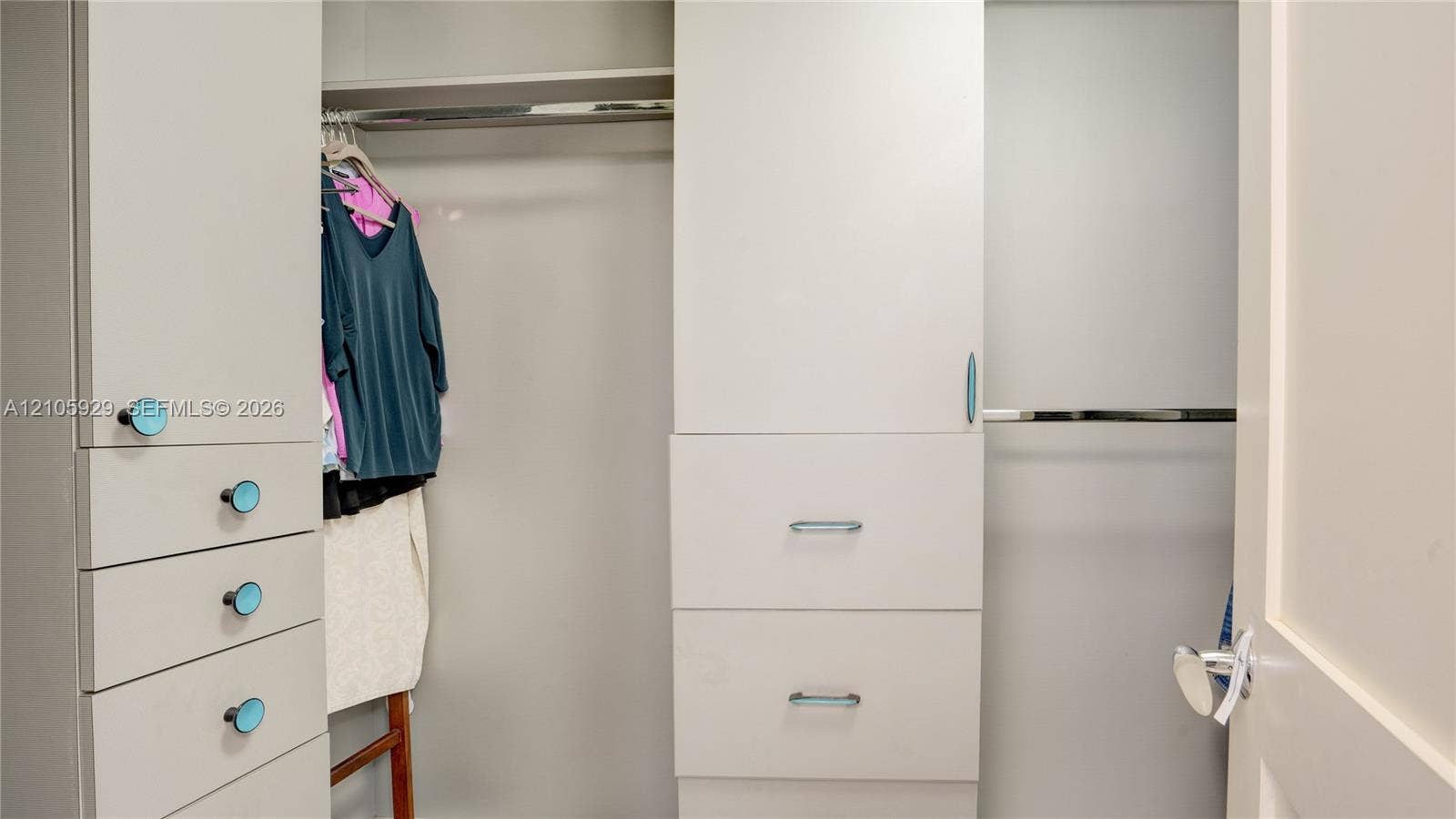 2655 Collins Avenue, #2301, Miami Beach, FL 33140 Custom built-in closet organization system featuring white cabinetry, multiple storage drawers, dual hanging rods, and integrated shelving