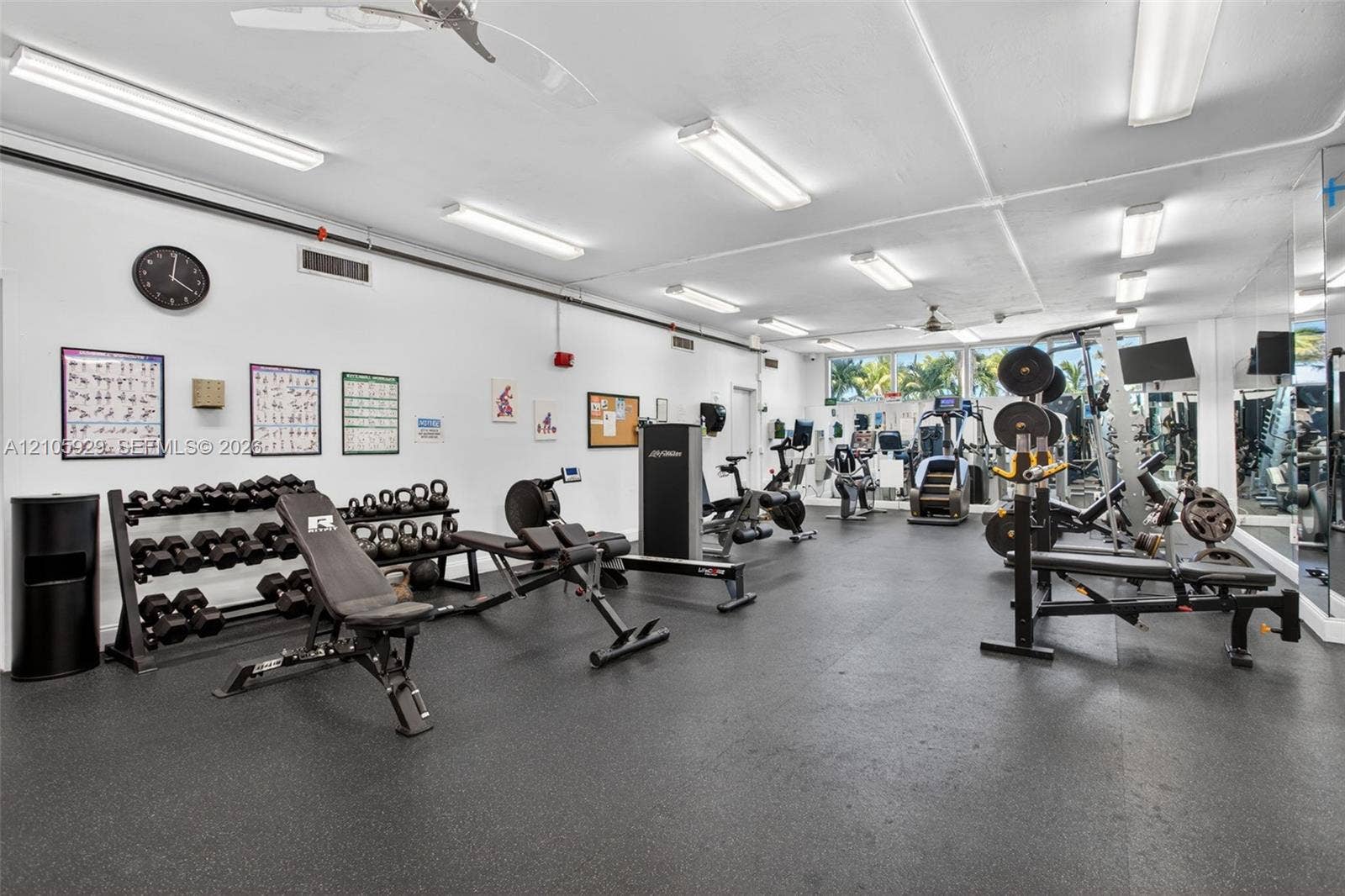 2655 Collins Avenue, #2301, Miami Beach, FL 33140 Fitness center featuring rubberized flooring, linear fluorescent lighting, ceiling-mounted fans, and full-length wall mirrors