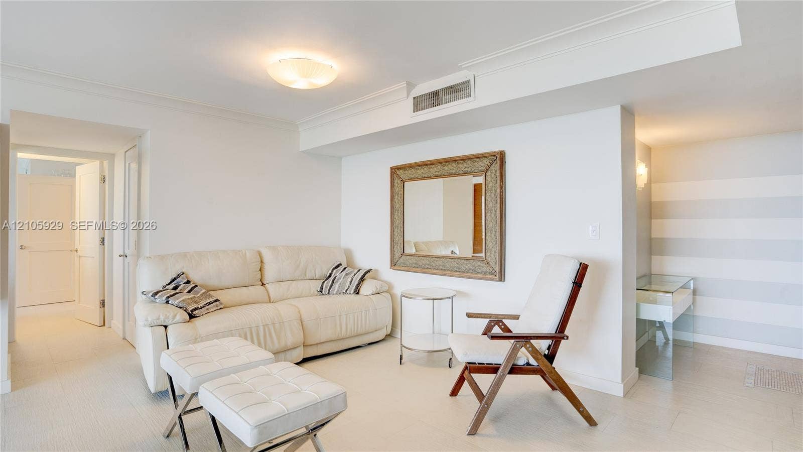 2655 Collins Avenue, #2301, Miami Beach, FL 33140 Interior space featuring neutral wall-to-wall carpeting, crown molding, a flush-mount ceiling light fixture, and a built-in recessed mirror