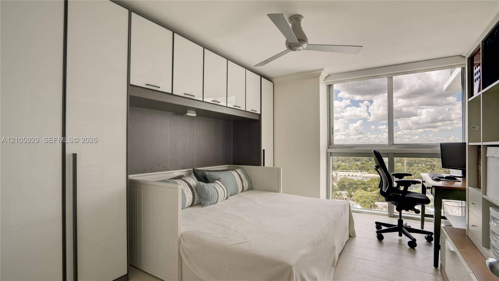 2655 Collins Avenue, #2301, Miami Beach, FL 33140 Floor-to-ceiling windows, built-in white cabinetry, integrated recessed lighting, and a modern ceiling fan