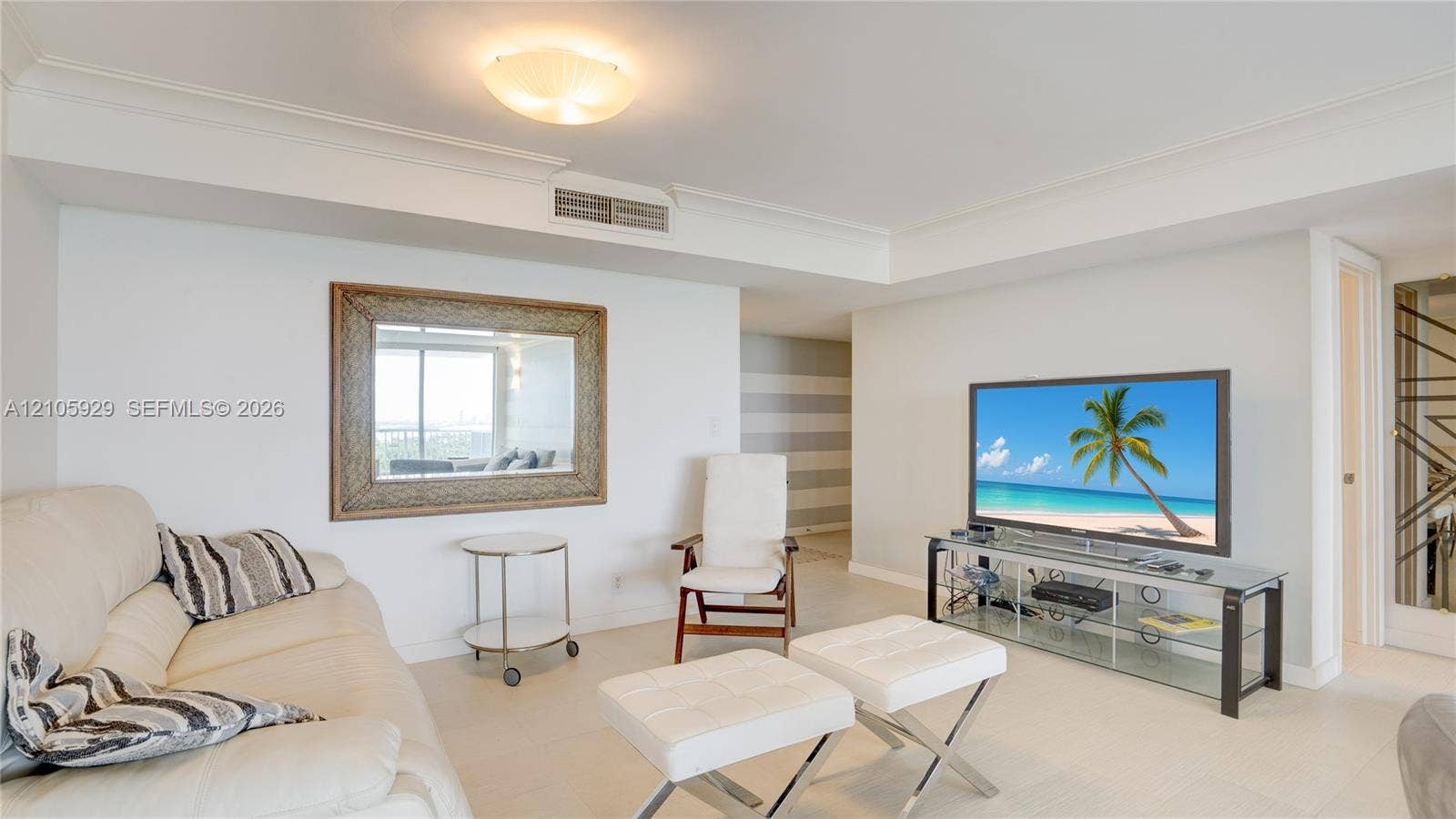 2655 Collins Avenue, #2301, Miami Beach, FL 33140 Neutral-toned interior space featuring light-colored tile flooring, crown molding, a semi-flush mount ceiling light fixture, and a decorative wall-mounted mirror