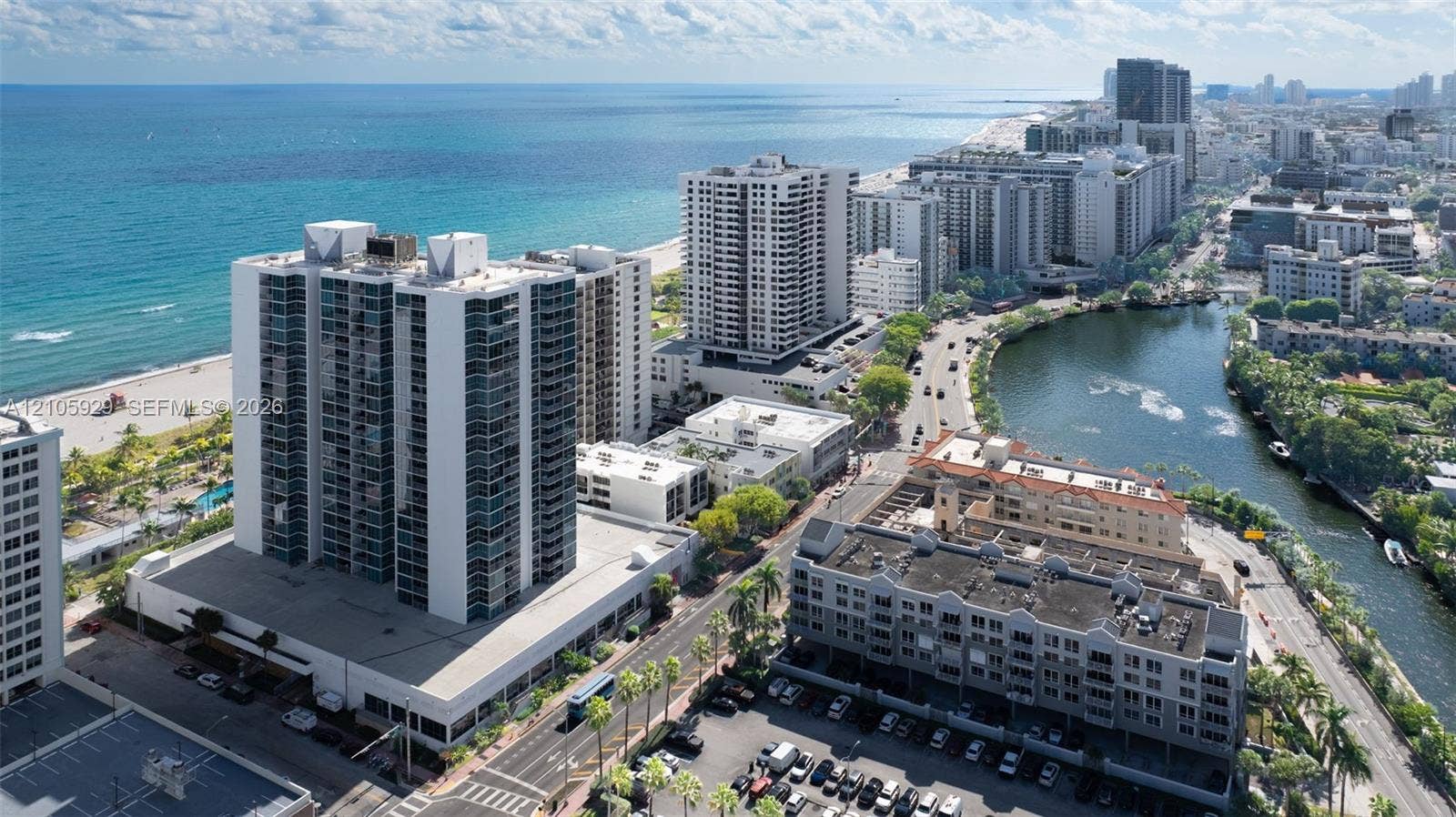 2655 Collins Avenue, #2301, Miami Beach, FL 33140 High-rise residential building featuring floor-to-ceiling glass windows, balconies, proximity to the coastline, and waterfront positioning