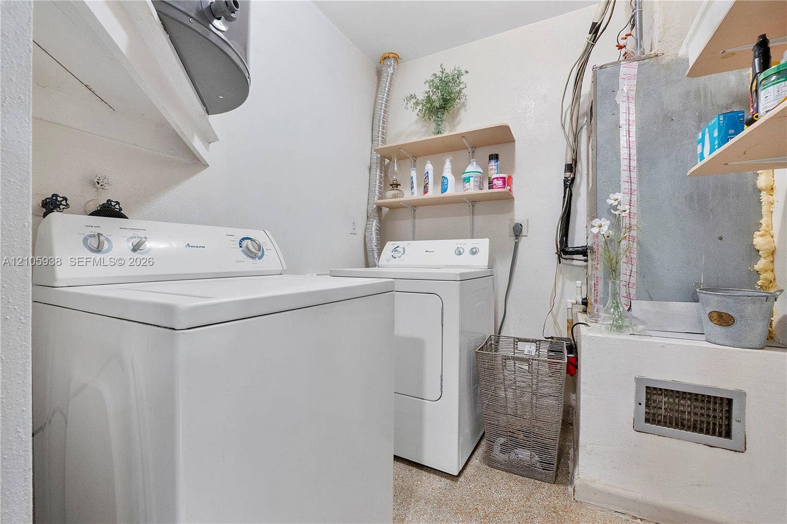 8310 NW 10th Street, Pembroke Pines, FL 33024 Laundry area featuring wall-mounted wooden shelving, a dedicated space for laundry appliances, and a raised concrete utility platform