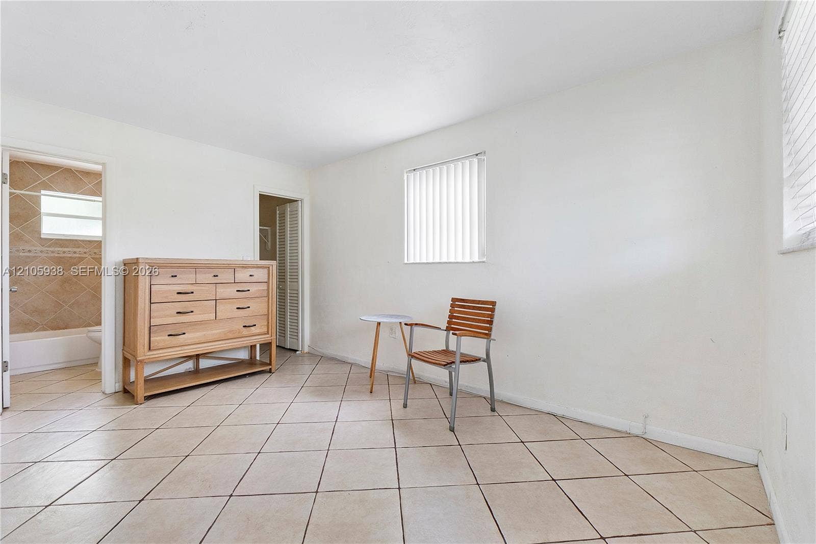 8310 NW 10th Street, Pembroke Pines, FL 33024 Neutral-toned ceramic tile flooring, vertical window blinds, and louvered closet doors