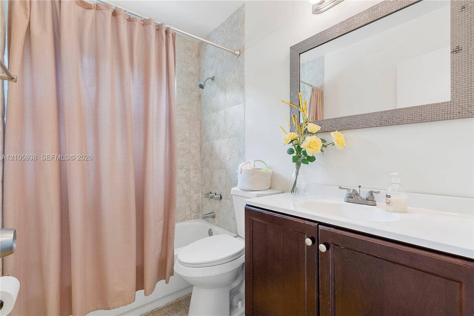 8310 NW 10th Street, Pembroke Pines, FL 33024 Bathroom featuring a vanity with dark-finish cabinetry, a white integrated countertop and basin, a framed wall mirror, and a tub-shower combination with neutral-toned wall tile