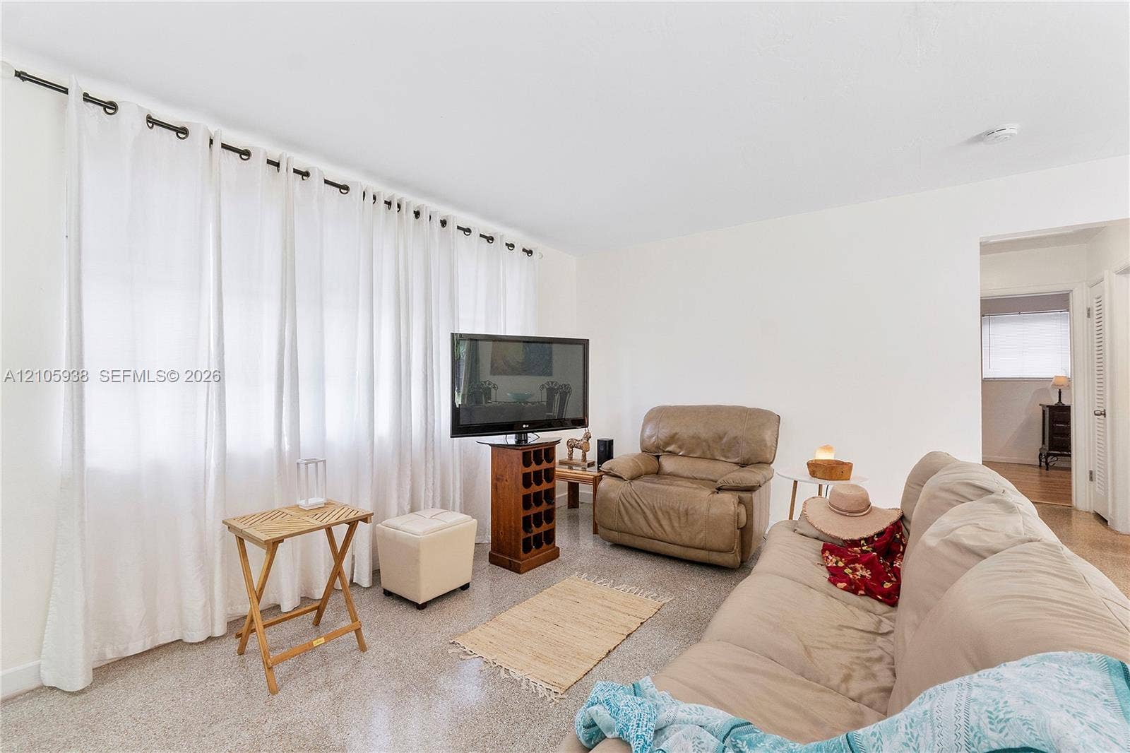 8310 NW 10th Street, Pembroke Pines, FL 33024 Neutral interior space featuring polished concrete flooring, extensive floor-to-ceiling curtain panels, and a recessed ceiling light