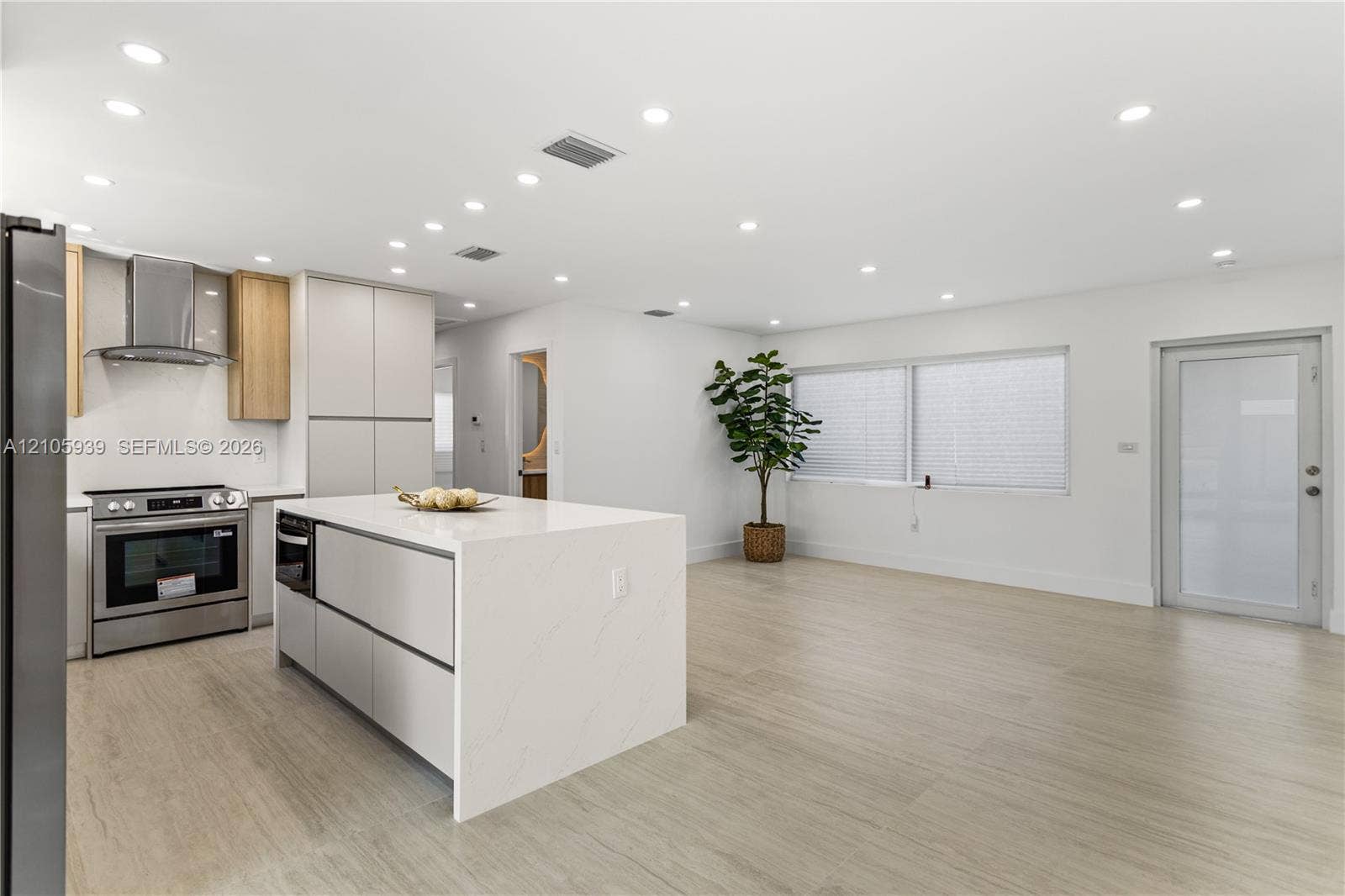 2850 NW 205th Street, Miami Gardens, FL 33056 Kitchen featuring a center island with a stone-finish countertop, stainless steel appliances, flat-panel cabinetry, recessed lighting, and wood-finish flooring