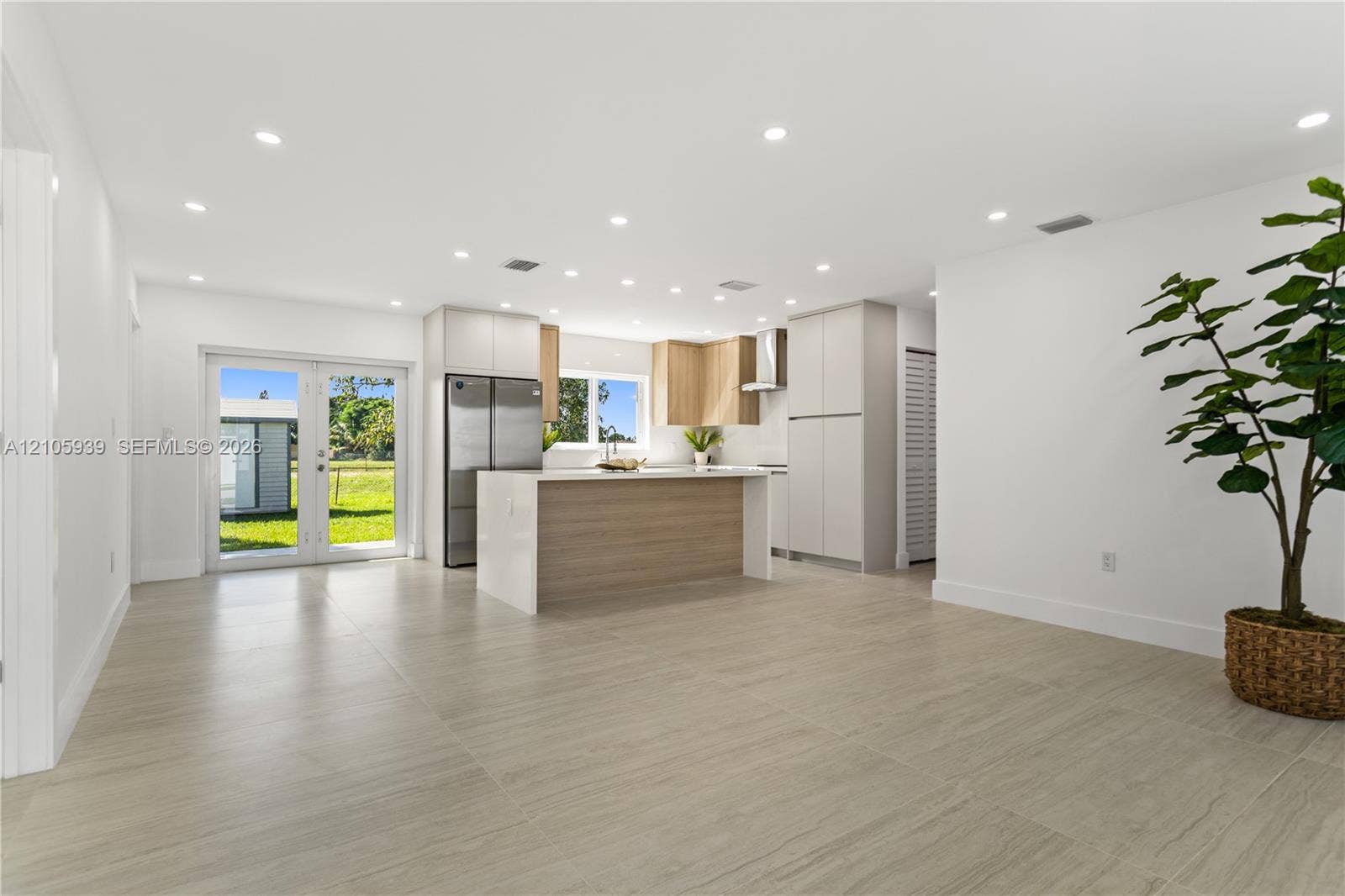 2850 NW 205th Street, Miami Gardens, FL 33056 Kitchen featuring a center island, light-finish cabinetry, stainless steel refrigerator, recessed lighting, and large-format tile flooring