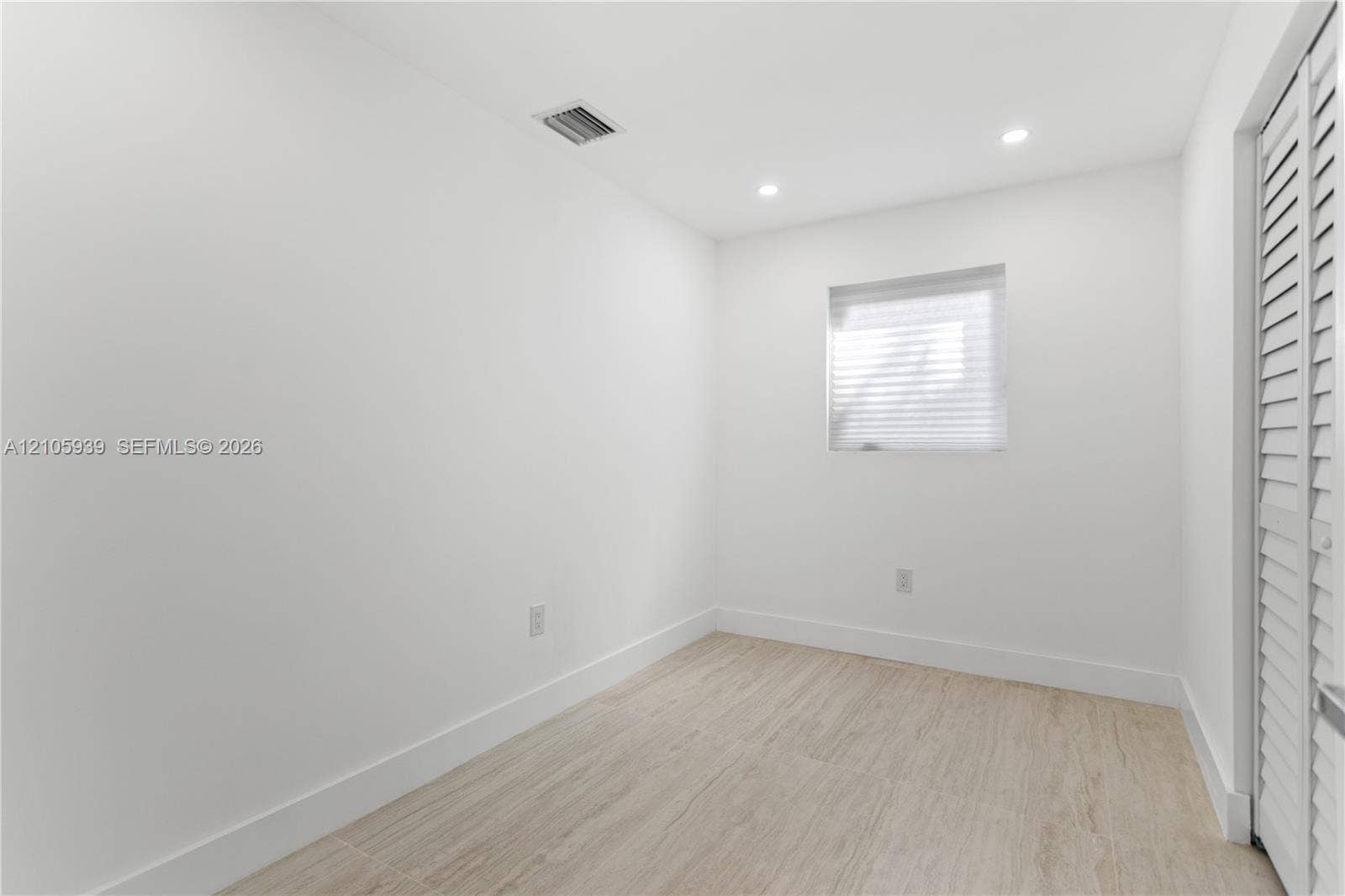 2850 NW 205th Street, Miami Gardens, FL 33056 Interior space featuring wood-finish tile flooring, recessed ceiling lighting, and louvered closet doors