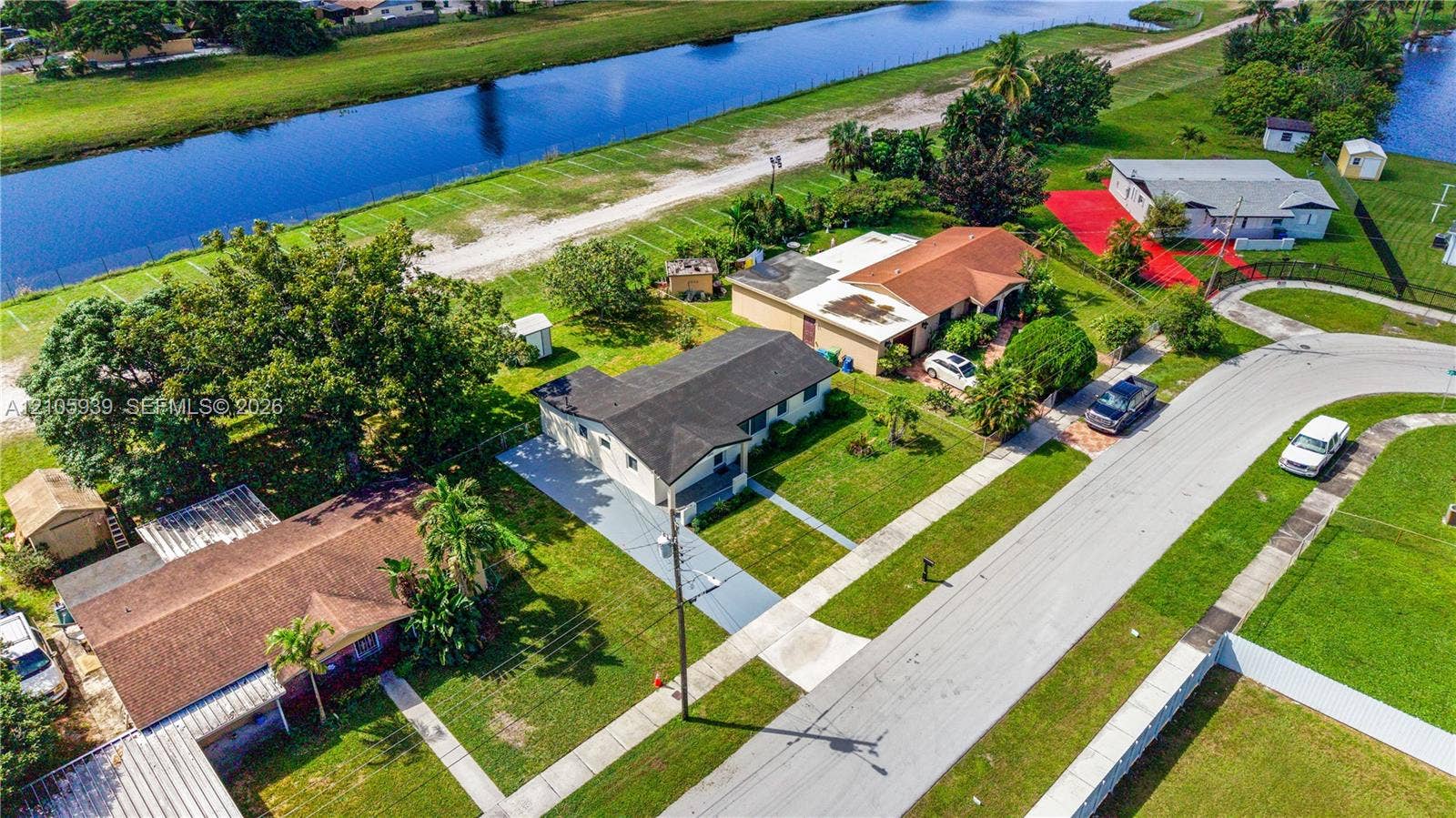 2850 NW 205th Street, Miami Gardens, FL 33056 Aerial perspective featuring residential lots with canal frontage, asphalt paved streets, concrete driveways, and mature landscaping
