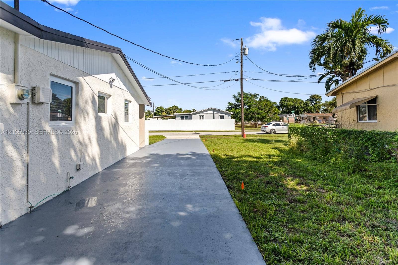 2850 NW 205th Street, Miami Gardens, FL 33056 Stucco exterior finish with white paint, single-story profile, and concrete driveway surface