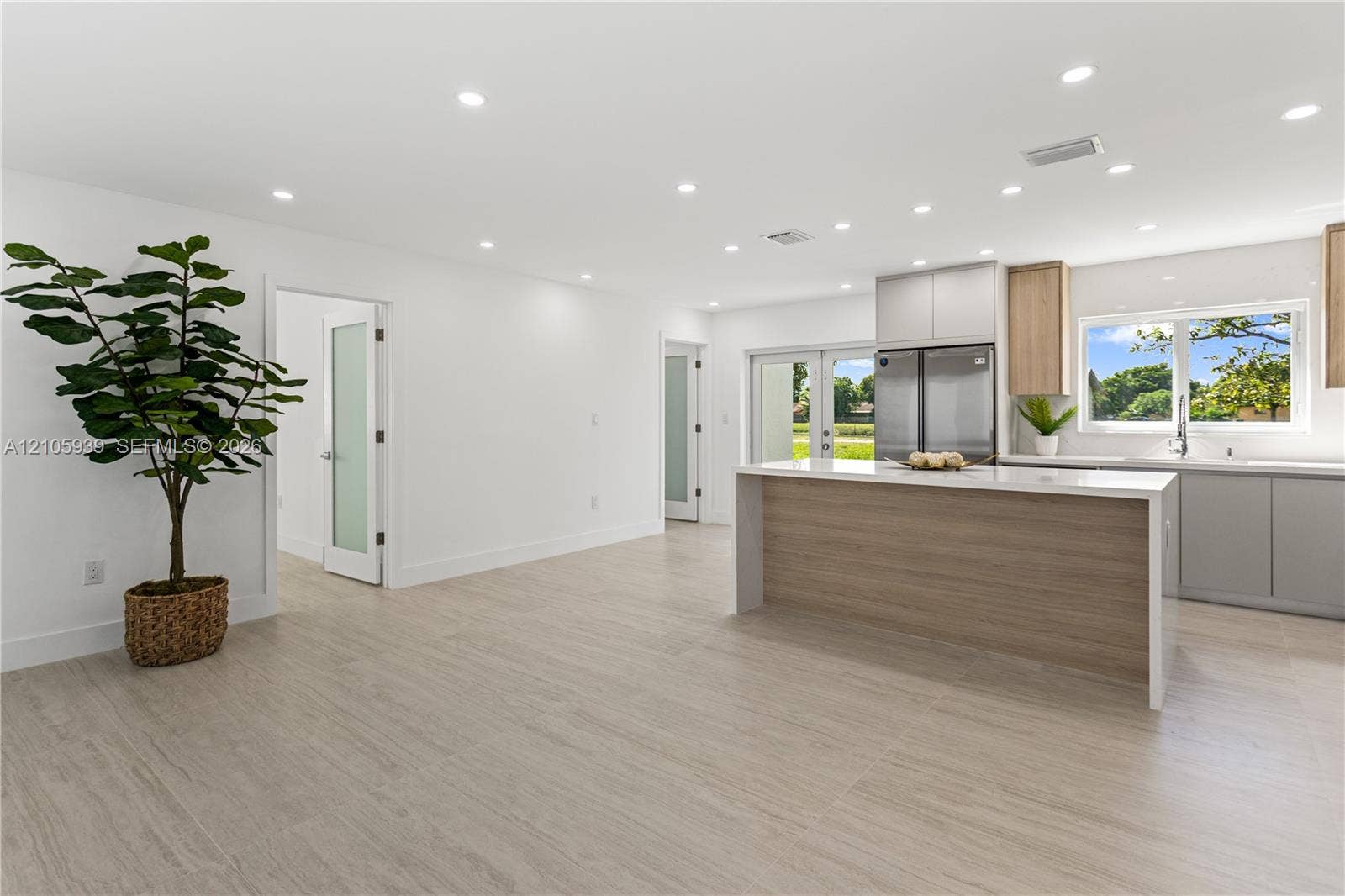 2850 NW 205th Street, Miami Gardens, FL 33056 Open concept space featuring light-toned wood-finish flooring, recessed lighting, and a kitchen island with a neutral-toned base