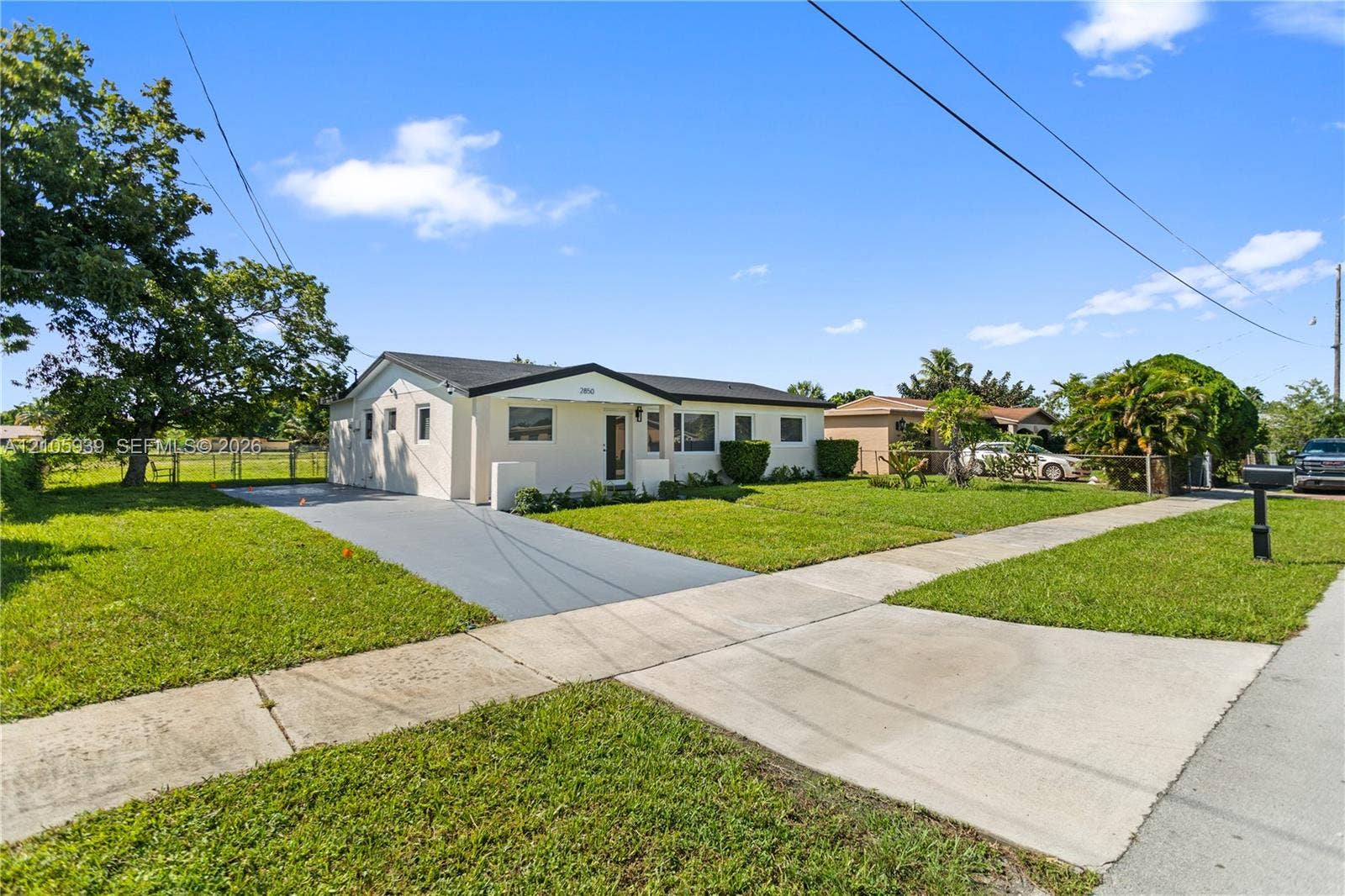 2850 NW 205th Street, Miami Gardens, FL 33056 Single-story exterior featuring a light-toned stucco facade, a dark-toned roof, and a paved driveway