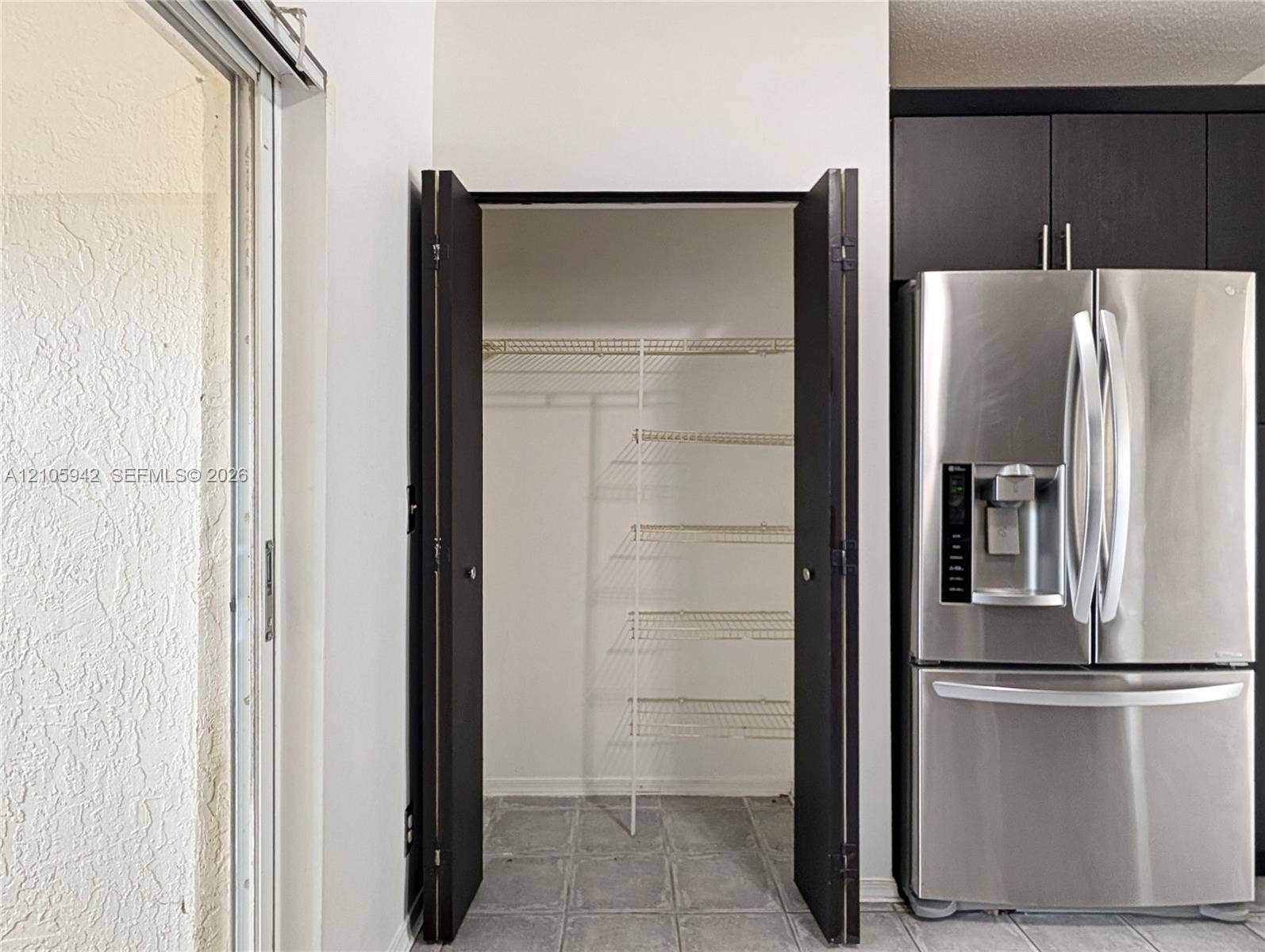 271 Duval Court, Weston, Weston, FL 33326 Stainless steel french-door refrigerator with built-in water dispenser, dark-toned cabinetry, and walk-in storage closet with wire shelving