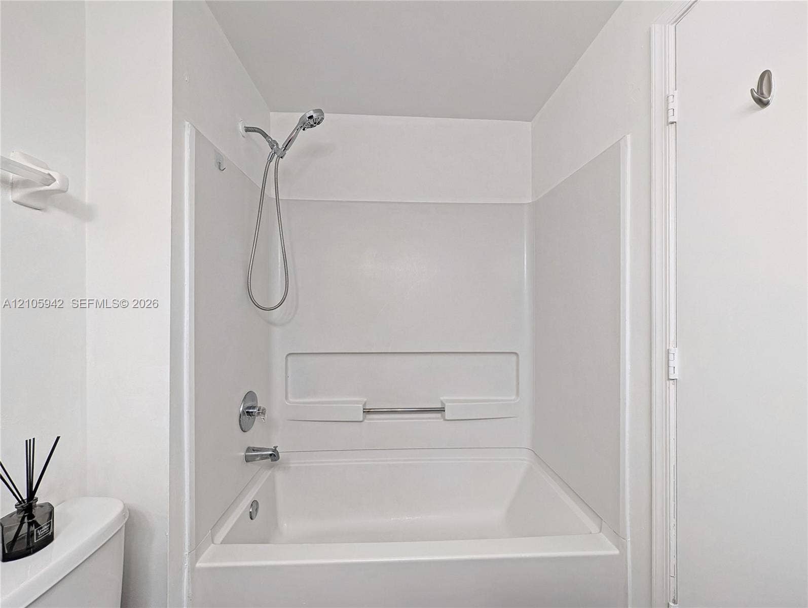 271 Duval Court, Weston, Weston, FL 33326 Tub-shower combination featuring a white surround, integrated shelving, and a chrome handheld shower head