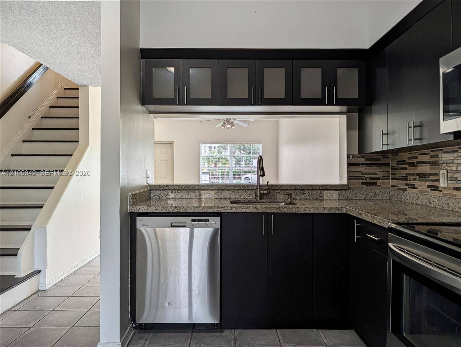 271 Duval Court, Weston, Weston, FL 33326 Kitchen featuring dark-finish flat-panel cabinetry, stone-style countertops, stainless steel dishwasher, and horizontal mosaic tile backsplash