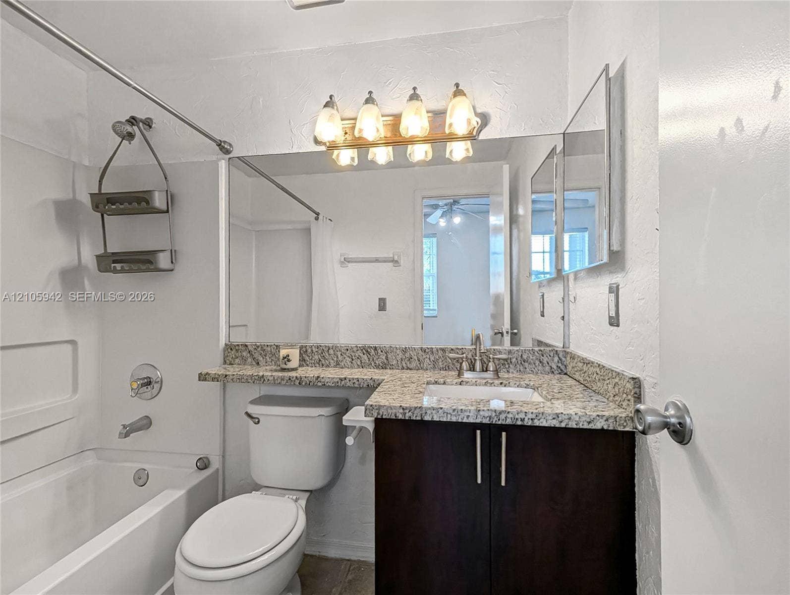 271 Duval Court, Weston, Weston, FL 33326 Bathroom featuring a dark-finish vanity with stone-patterned countertop, integrated basin, large wall-mounted mirror, and multi-bulb vanity lighting