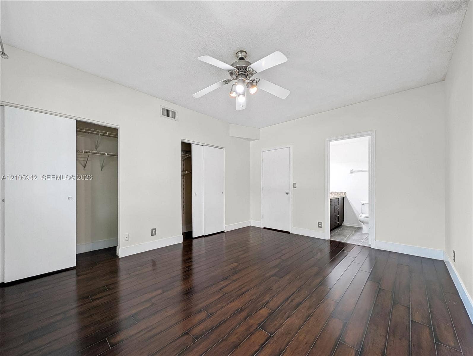 271 Duval Court, Weston, Weston, FL 33326 Room featuring dark wood-finish flooring, a multi-blade ceiling fan with integrated lighting, and dual reach-in closets with sliding doors