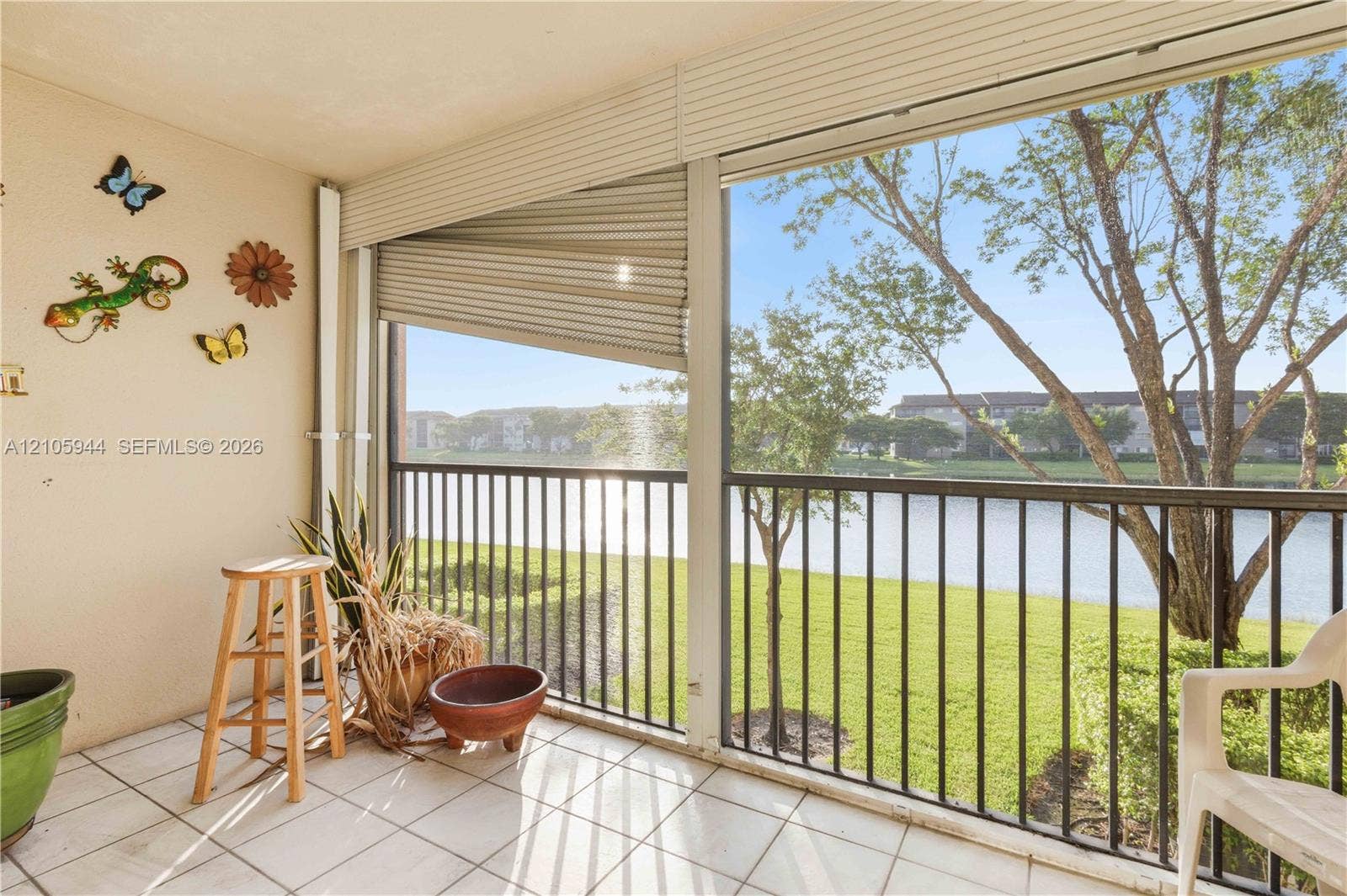 Enclosed porch featuring tile flooring, metal railings, and retractable privacy shades