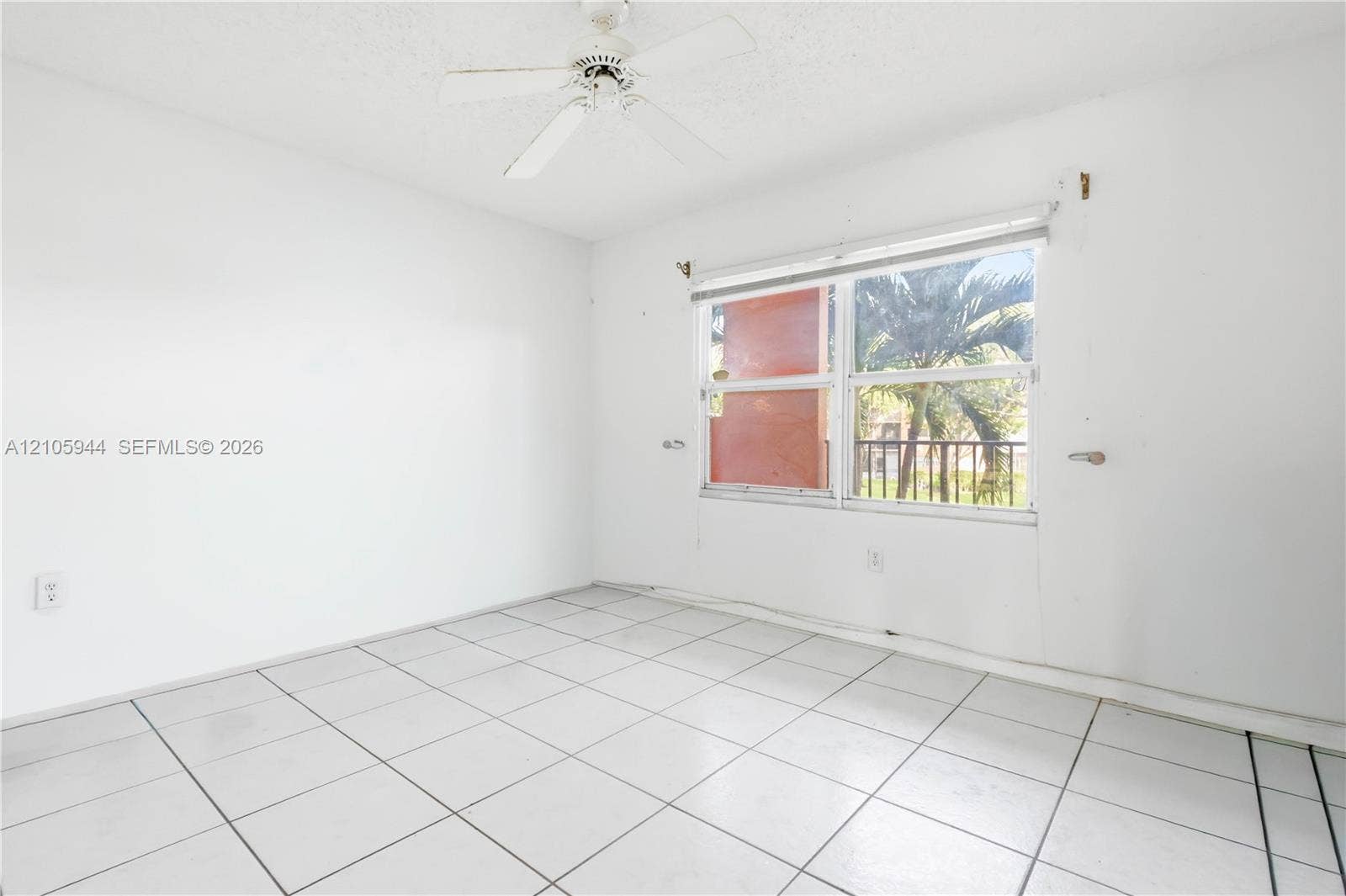 White-tiled flooring, ceiling fan with light fixture, and dual-pane window with white blinds