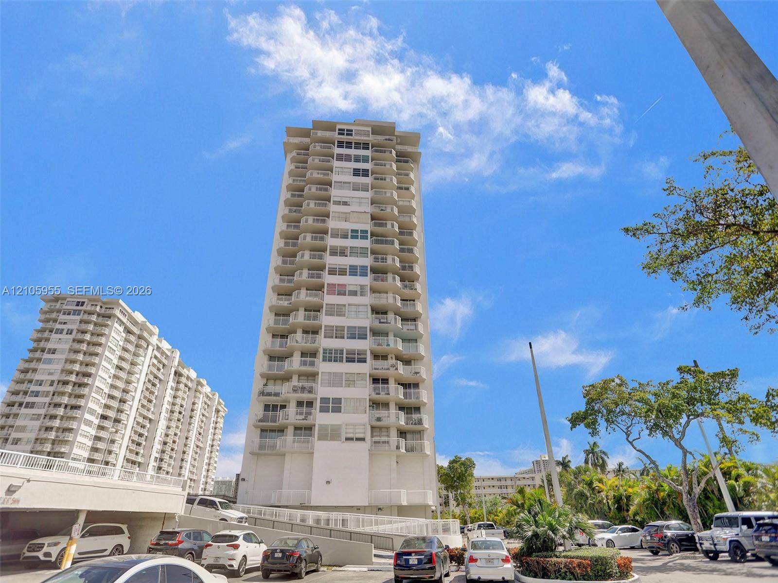 18011 Biscayne Boulevard, #1904, Aventura, FL 33160 High-rise residential exterior featuring white concrete facade, stacked private balconies, and covered parking structure