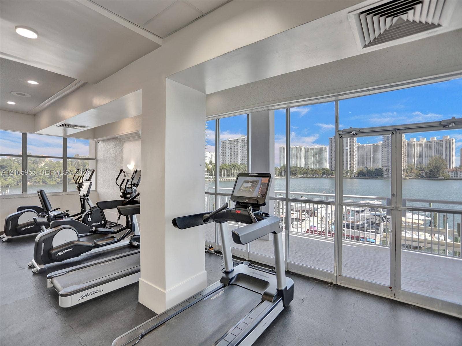 18011 Biscayne Boulevard, #1904, Aventura, FL 33160 Fitness center featuring expansive floor-to-ceiling windows, dual glass doors, recessed lighting, and rubber flooring