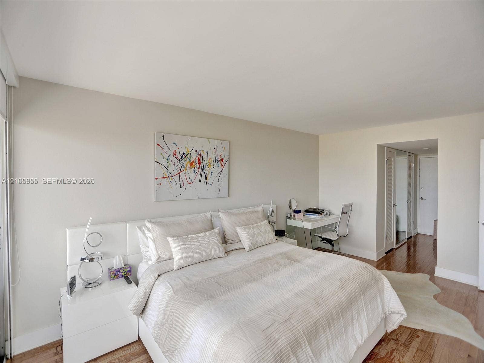 18011 Biscayne Boulevard, #1904, Aventura, FL 33160 Room featuring wood-finish flooring, neutral wall tones, and floor-to-ceiling mirrored closet doors