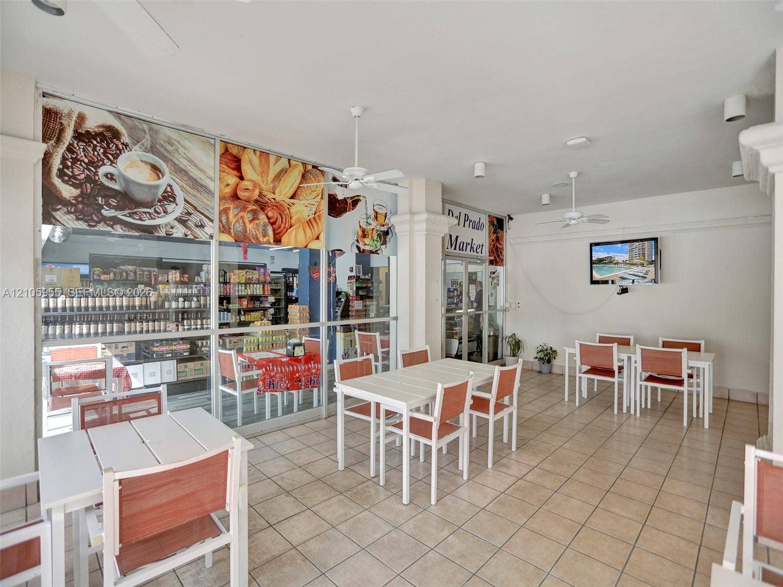 18011 Biscayne Boulevard, #1904, Aventura, FL 33160 Covered patio featuring large-format floor tiling, multiple ceiling-mounted fans, and full-height glass storefront windows
