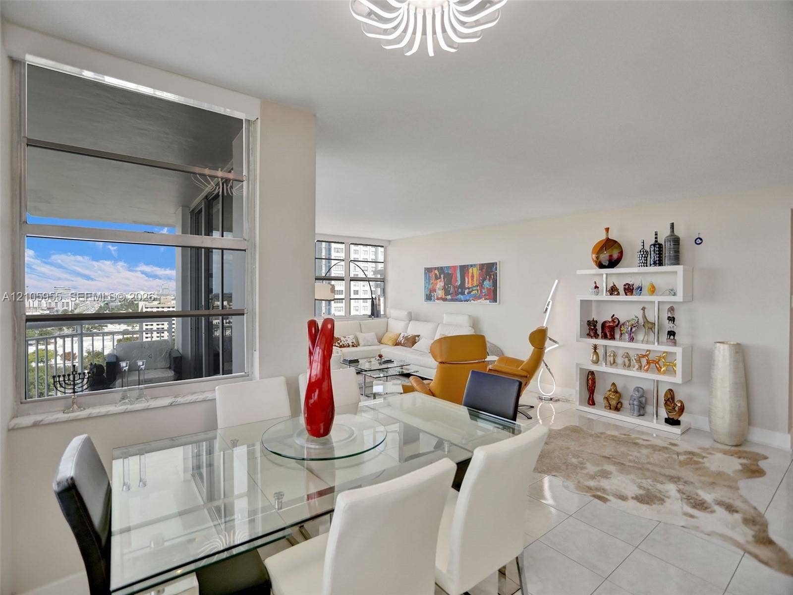 18011 Biscayne Boulevard, #1904, Aventura, FL 33160 Open-concept living space featuring large-format tile flooring, expansive floor-to-ceiling windows, built-in shelving unit, and decorative ceiling fixture