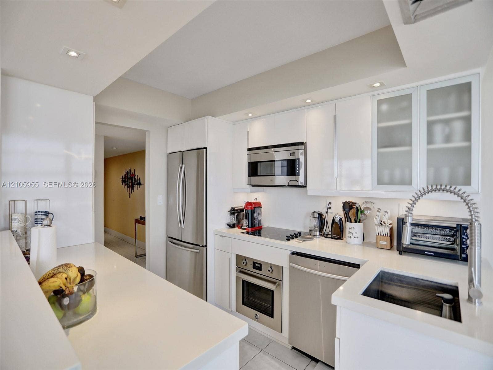 18011 Biscayne Boulevard, #1904, Aventura, FL 33160 Modern kitchen featuring high-gloss white cabinetry, polished white countertops, stainless steel appliances, recessed ceiling lighting, and a gooseneck faucet