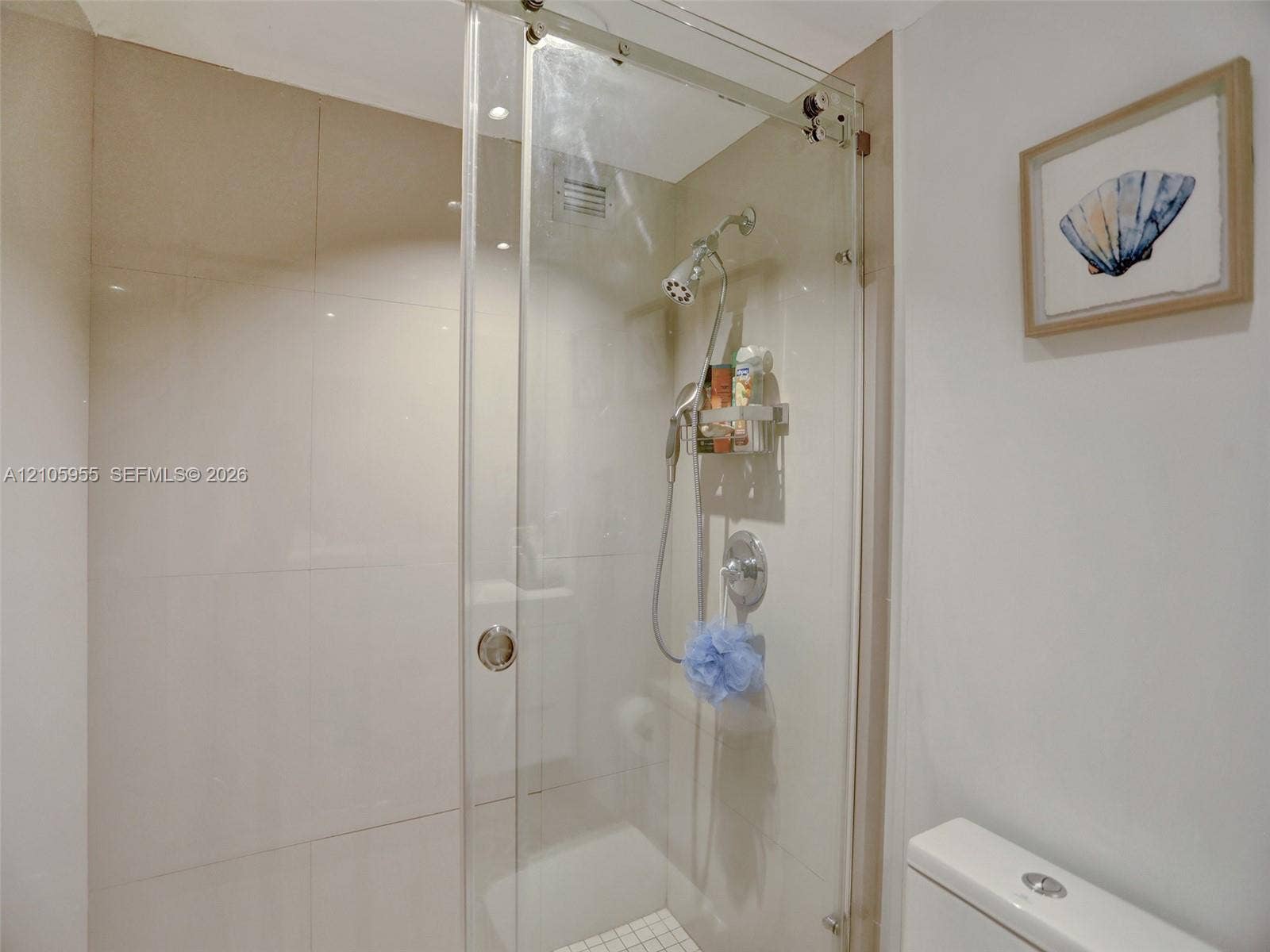 18011 Biscayne Boulevard, #1904, Aventura, FL 33160 Walk-in shower with floor-to-ceiling tile, frameless glass sliding enclosure, polished chrome rainfall showerhead, and handheld sprayer