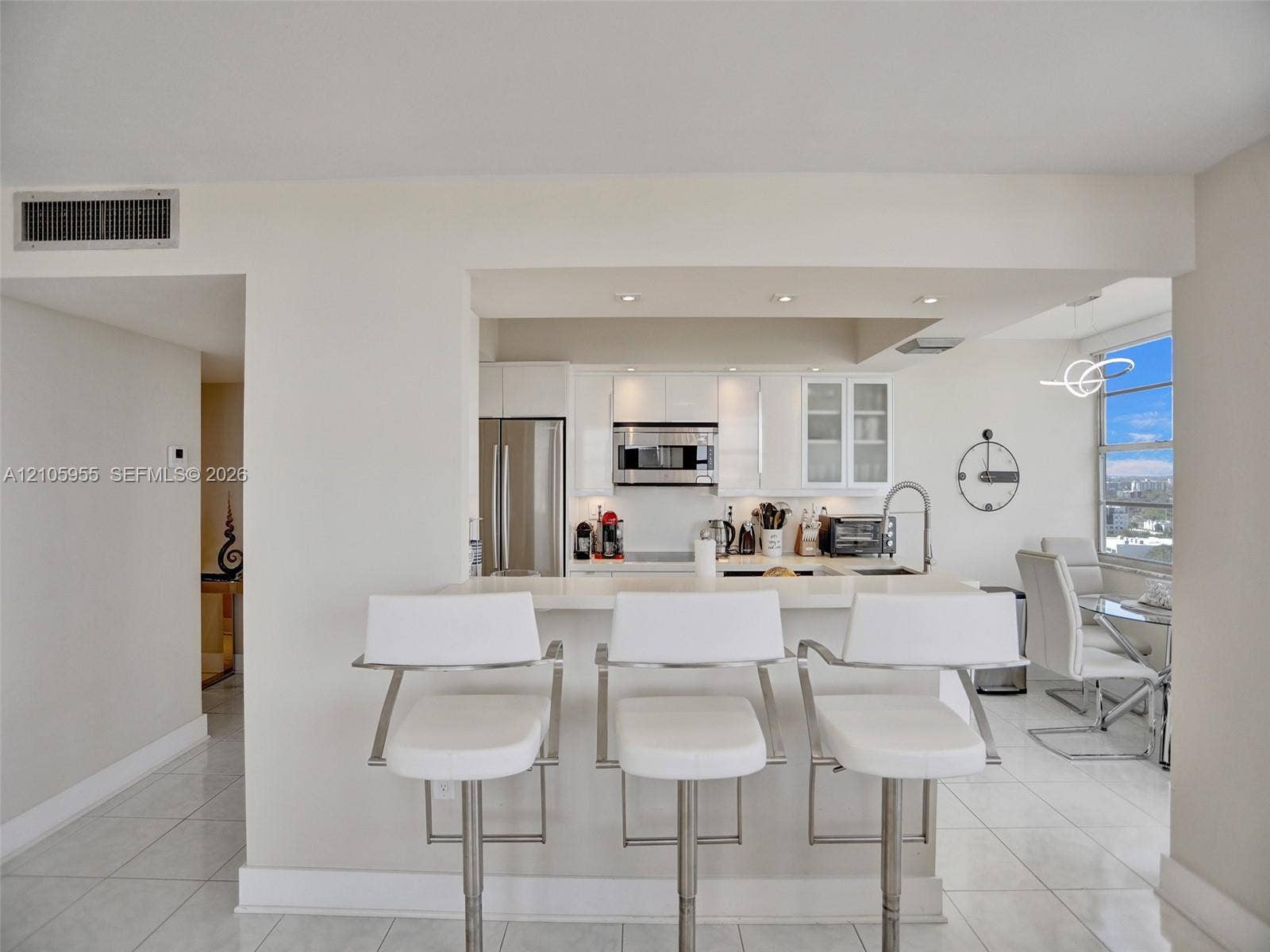 18011 Biscayne Boulevard, #1904, Aventura, FL 33160 Kitchen featuring white cabinetry, stainless steel appliances, recessed lighting, and a breakfast bar with a solid surface countertop