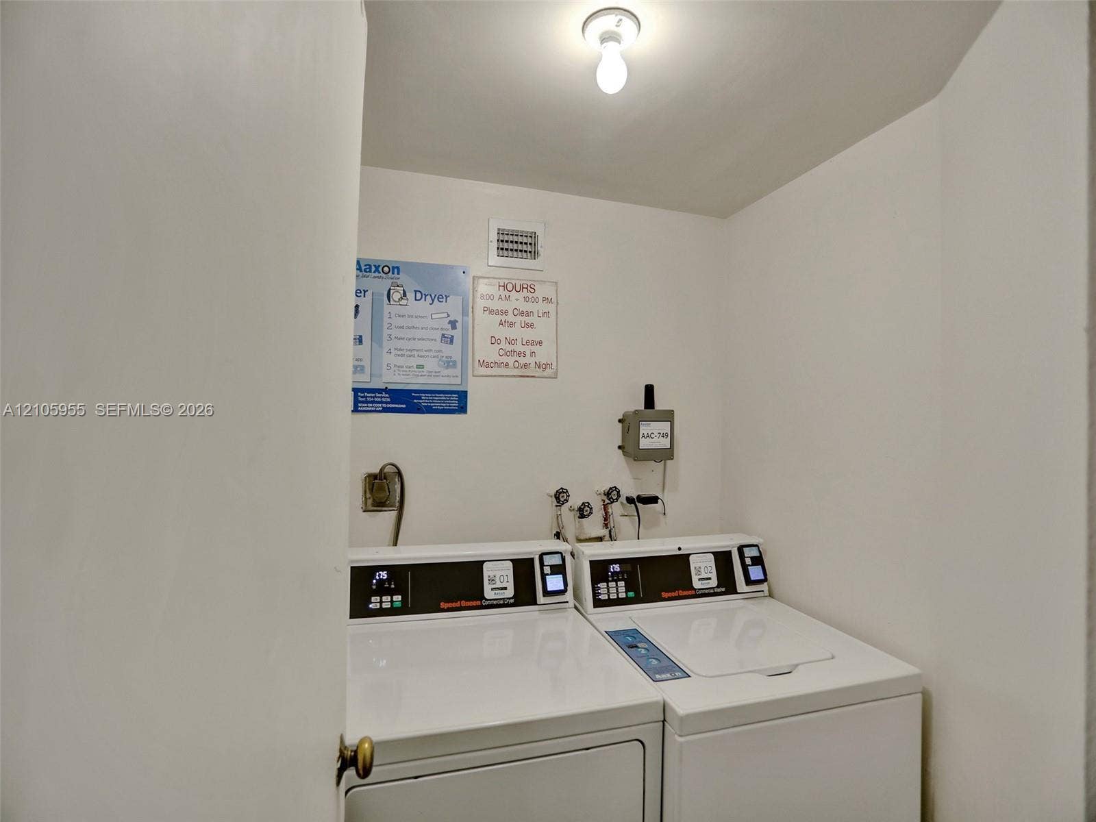 18011 Biscayne Boulevard, #1904, Aventura, FL 33160 Utility area featuring built-in commercial-grade laundry appliances, wall-mounted water hookups, and surface-mounted ceiling lighting