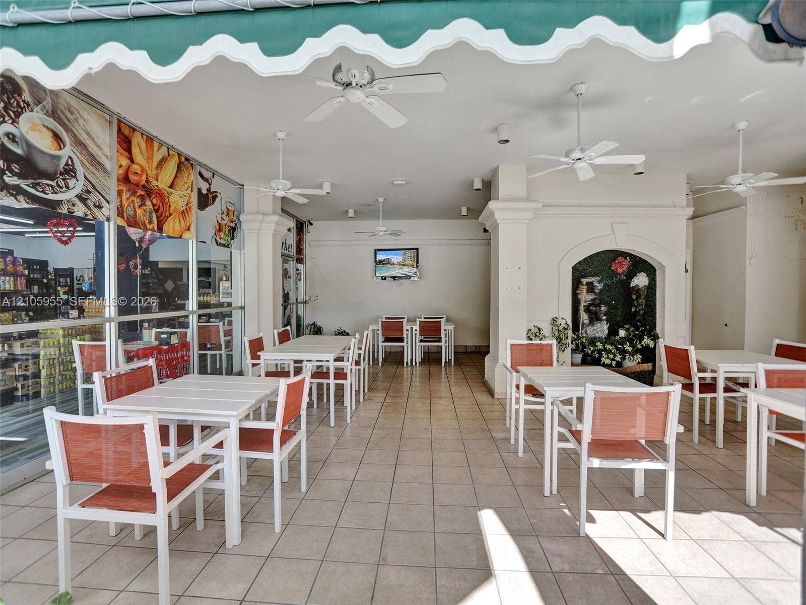 18011 Biscayne Boulevard, #1904, Aventura, FL 33160 Covered outdoor patio featuring tile flooring, four ceiling fans, a scalloped fabric awning, and a decorative arched alcove