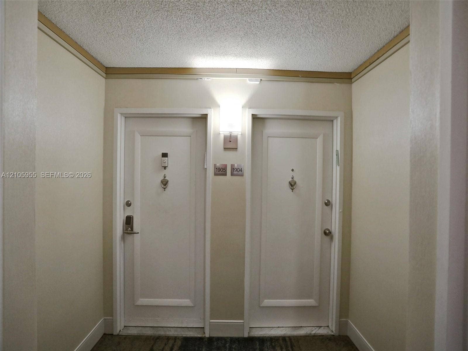 18011 Biscayne Boulevard, #1904, Aventura, FL 33160 Solid-core entry doors featuring brushed nickel hardware, door knockers, and wall-mounted sconce lighting