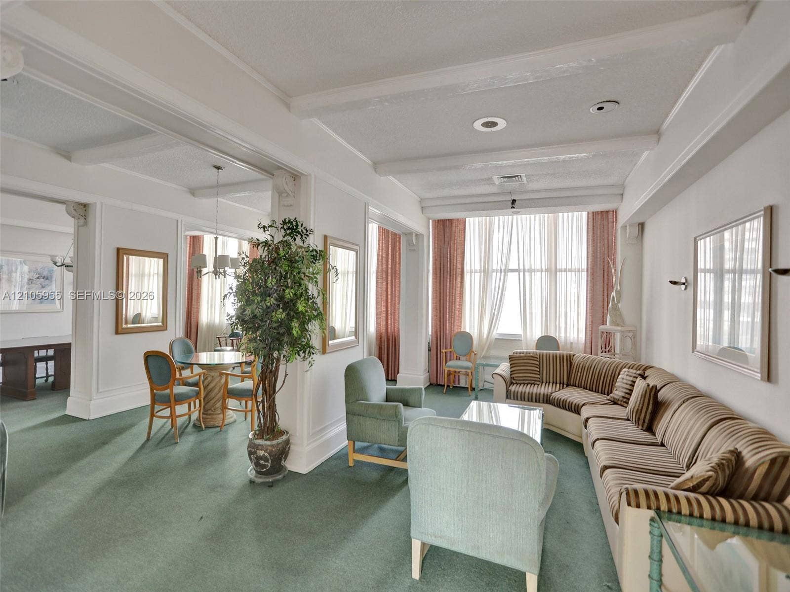 18011 Biscayne Boulevard, #1904, Aventura, FL 33160 Expansive living area featuring beamed ceilings, floor-to-ceiling windows, wall-mounted light fixtures, and architectural columns