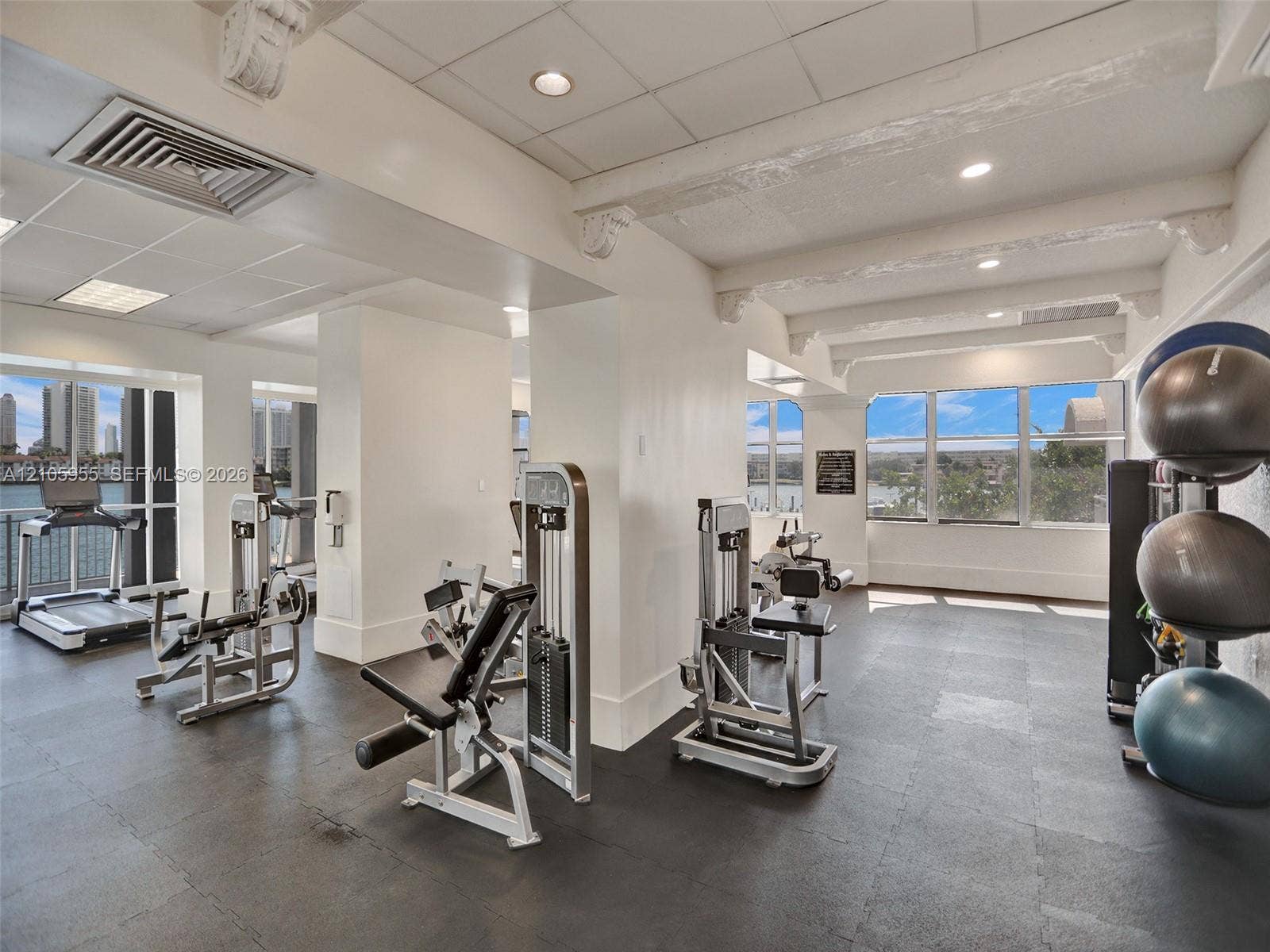 18011 Biscayne Boulevard, #1904, Aventura, FL 33160 Fitness center featuring high ceilings with exposed decorative corbels, resilient flooring, extensive window walls, and recessed lighting