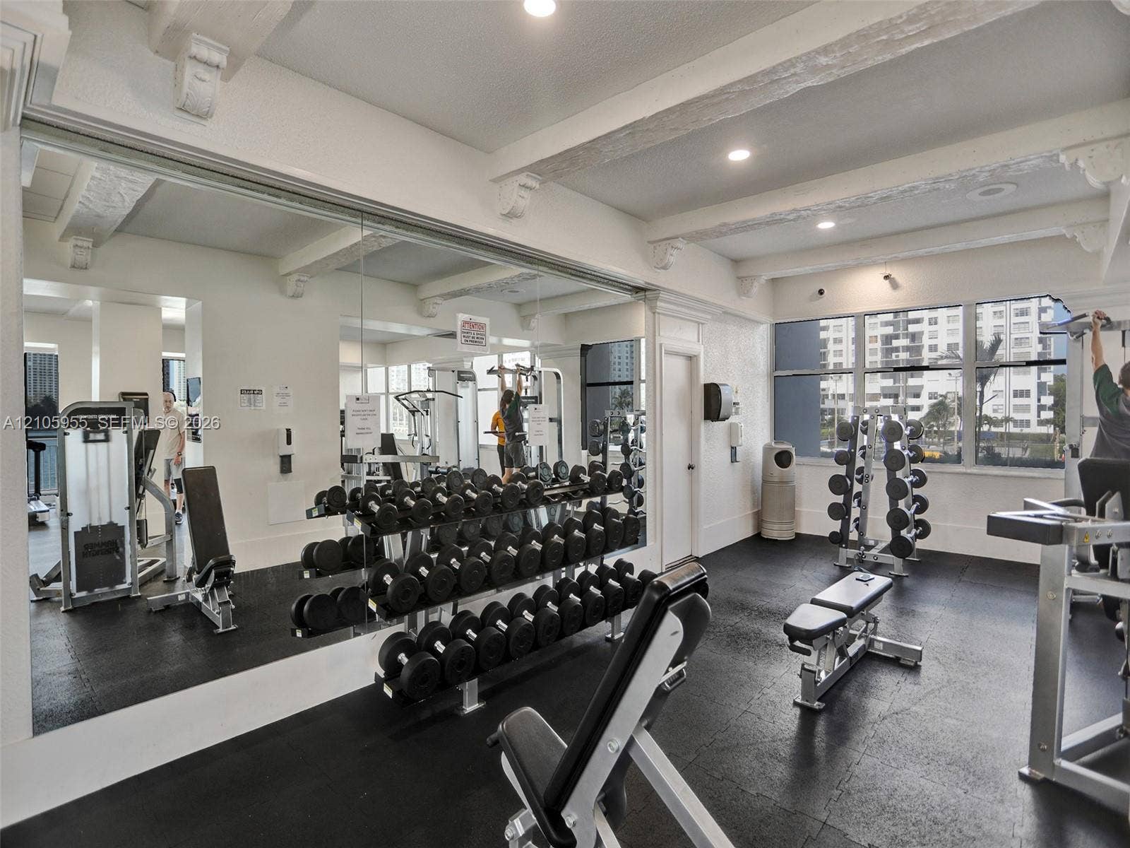 18011 Biscayne Boulevard, #1904, Aventura, FL 33160 Fitness area featuring rubberized flooring, expansive wall-to-wall mirrors, exposed ceiling beams with corbel detailing, and oversized windows