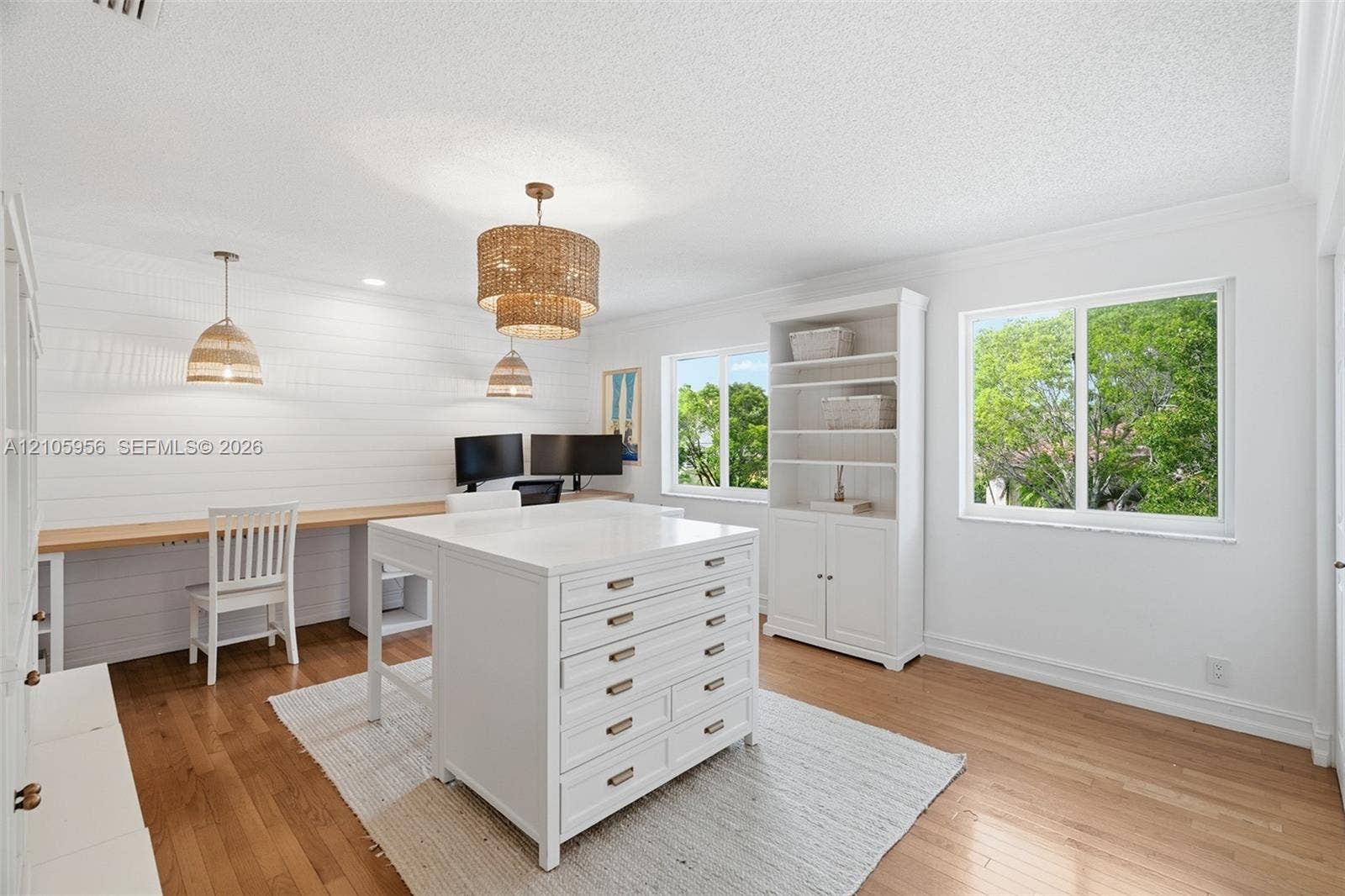 1154 Croton Court, Weston, Weston, FL 33327 Room featuring white shiplap walls, built-in wooden desk, wood-finish flooring, white custom cabinetry with drawers, and multi-tiered pendant lighting