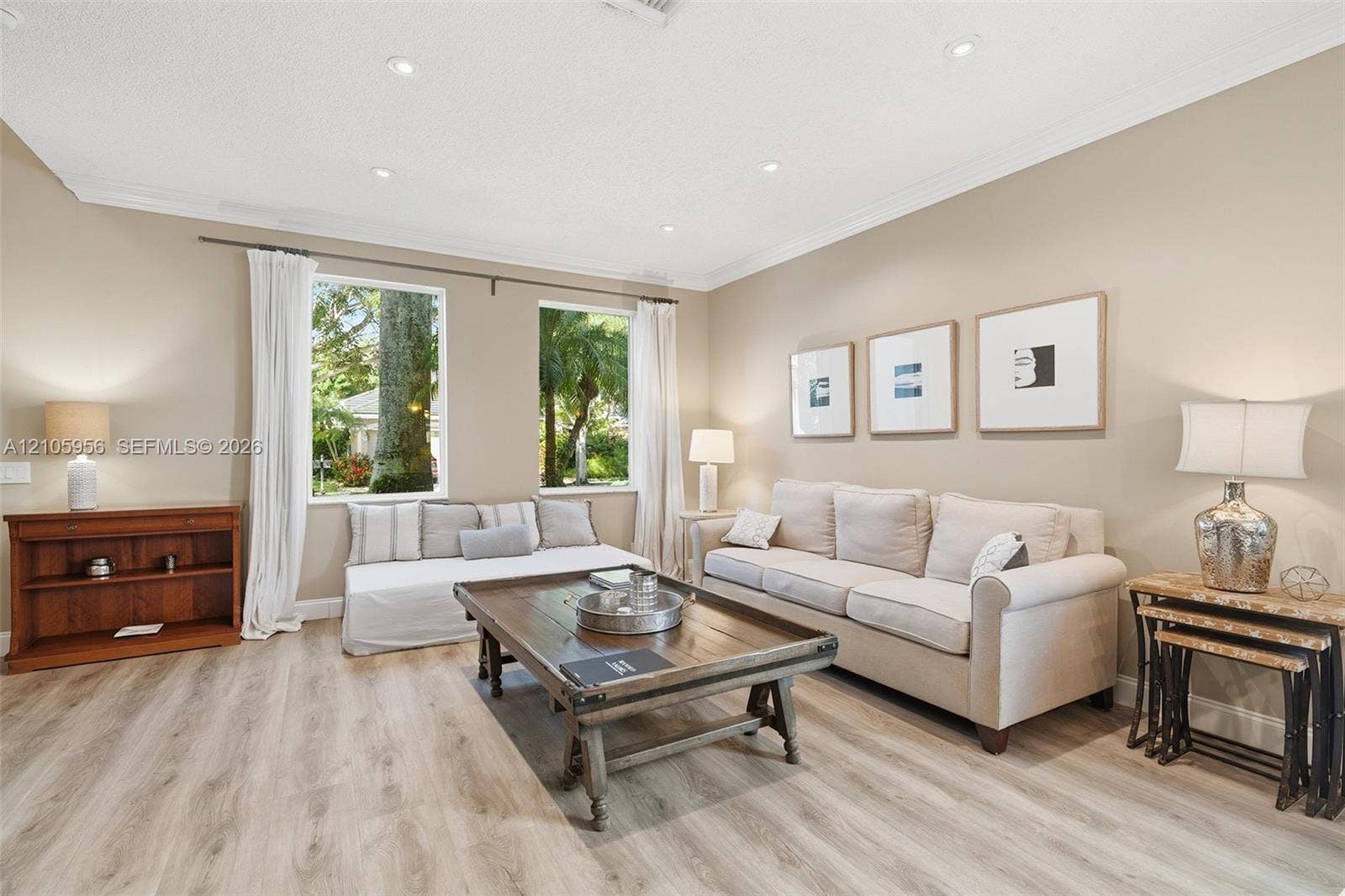1154 Croton Court, Weston, Weston, FL 33327 Living space featuring light-tone wood-finish flooring, recessed lighting, crown molding, and large rectangular windows with exterior greenery