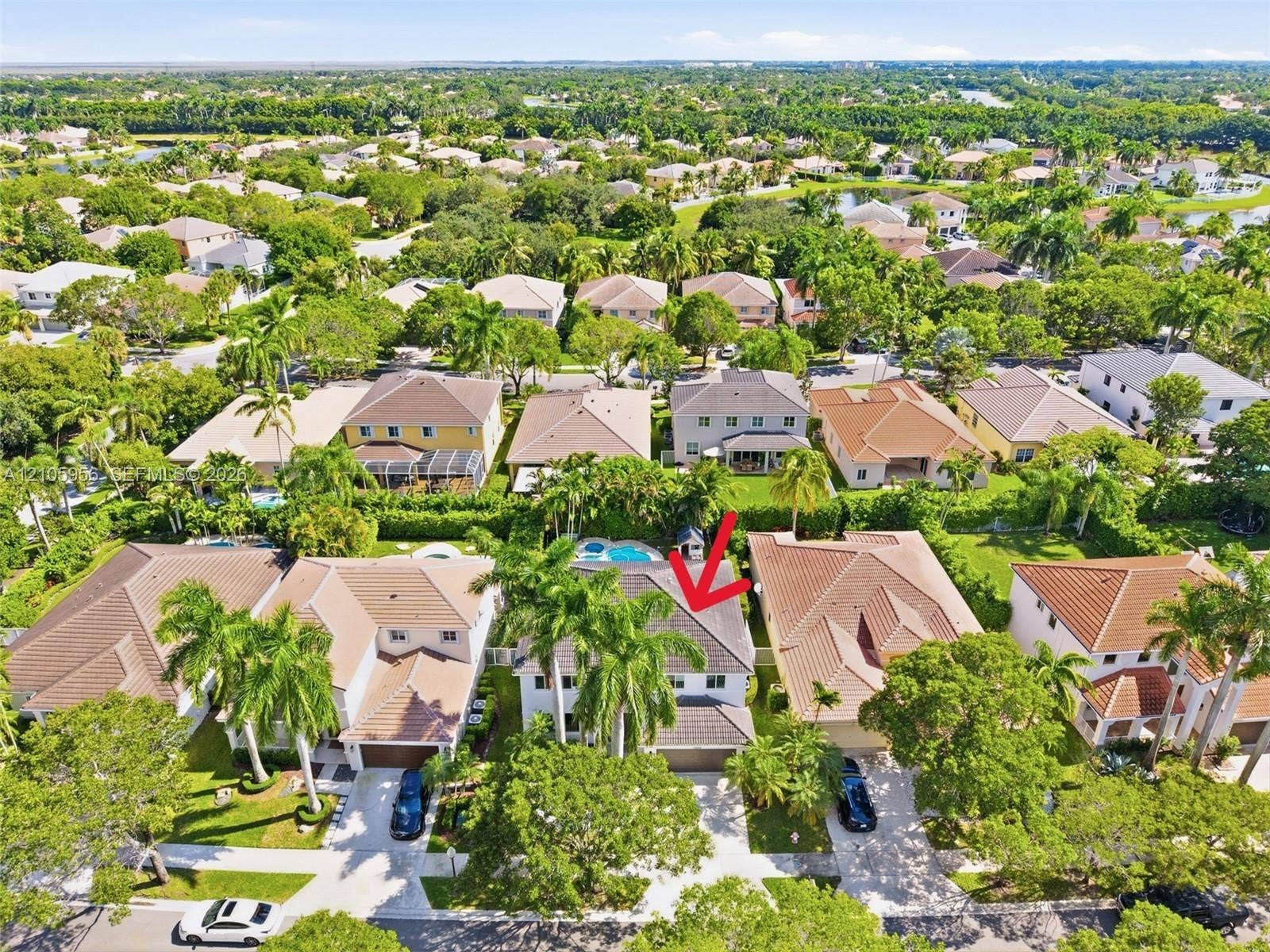 1154 Croton Court, Weston, Weston, FL 33327 Aerial perspective featuring a two-story residence with a concrete tile roof, integrated swimming pool, attached multi-car garage, and mature palm trees